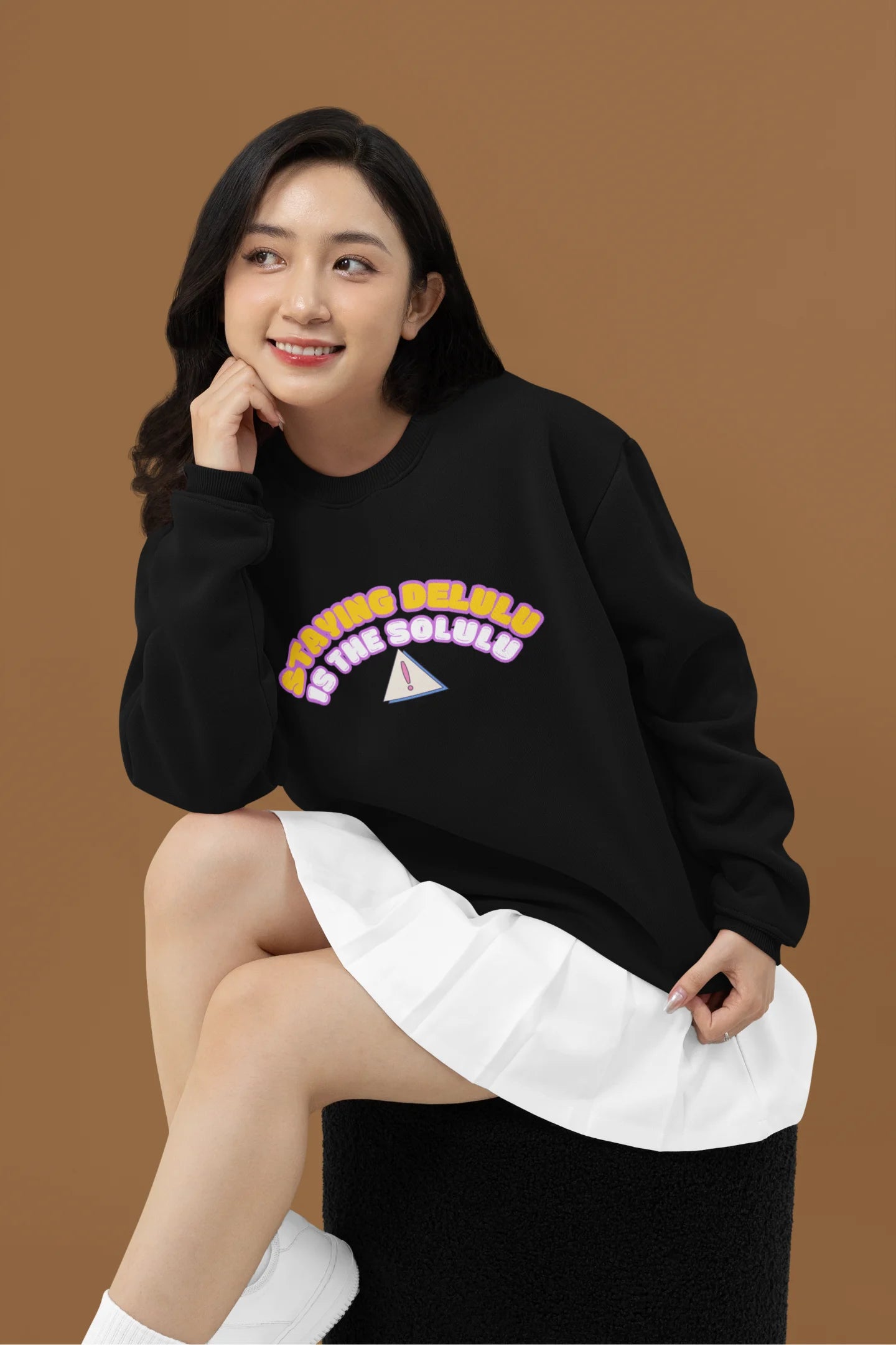 3rd front view of female model wearing a black sweatshirt with the hilarious message "Stay Delulu" in a bold design. Ideal for those who love trendy slang and lighthearted humor.