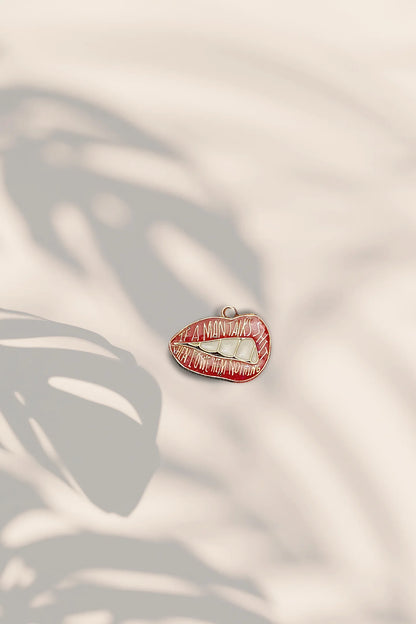 Second image of an charm featuring the Taylor Swift phrase "You Owe Him Nothing" on a lip design. Perfect for all Swifties.