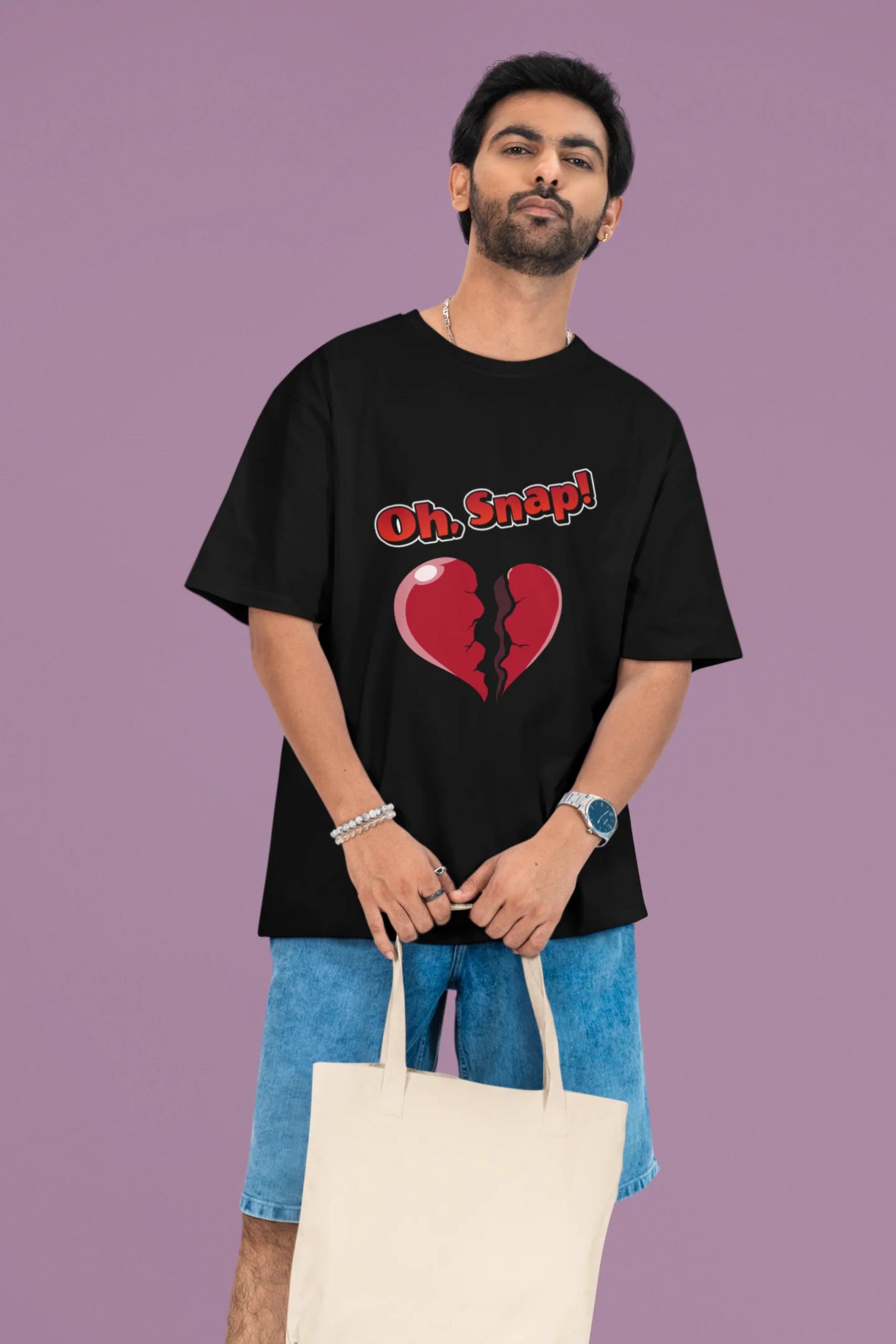 3rd front view of a male model wearing a black oversized t-shirt with the text "Oh Snap!" and a broken heart symbol underneath.