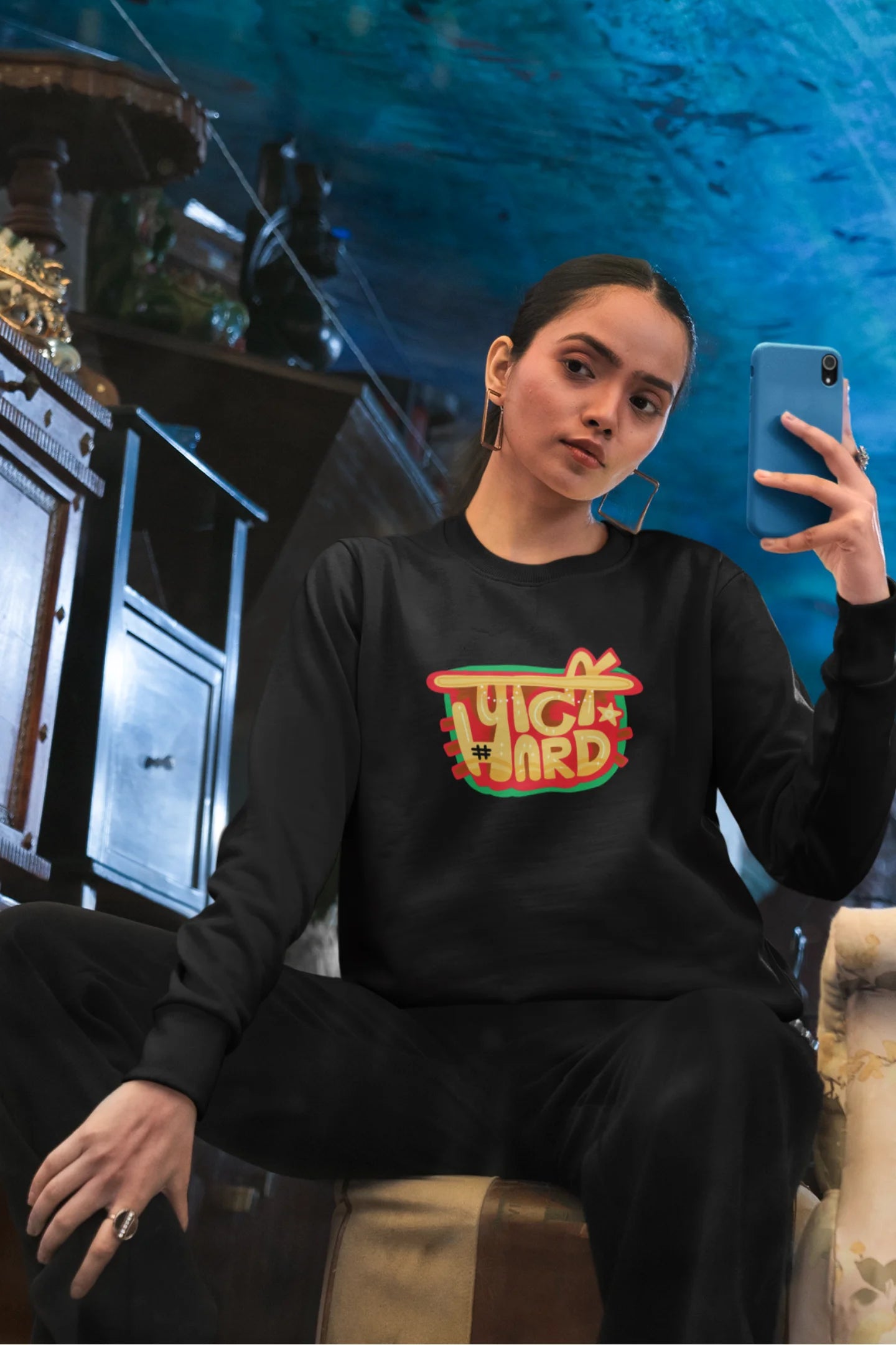 5th front view of a female model wearing a black oversized t-shirt with the phrase "Party Hard" in an energetic Hindi.