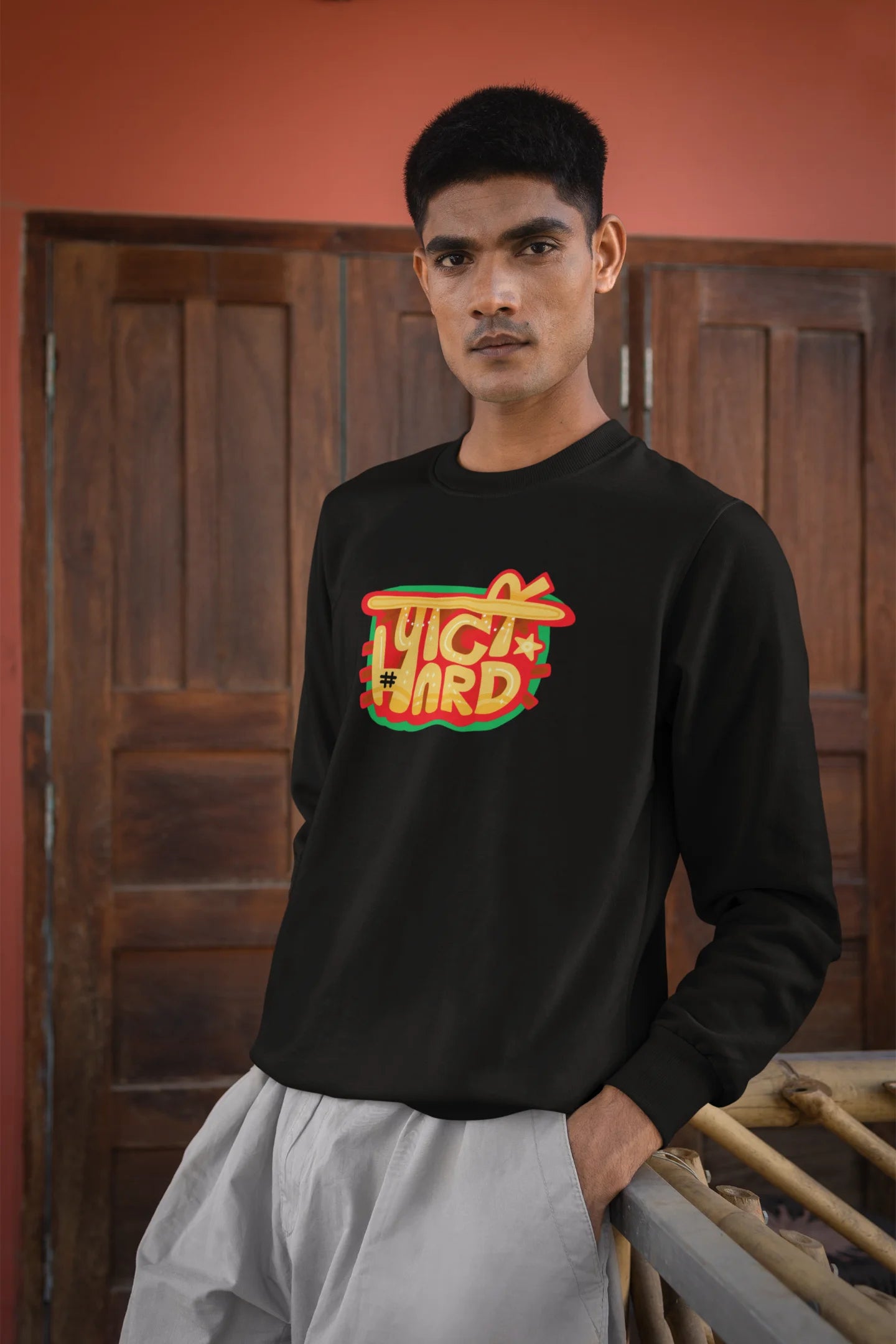 4th front view of a male model wearing a black oversized t-shirt with the phrase "Party Hard" in an energetic Hindi.