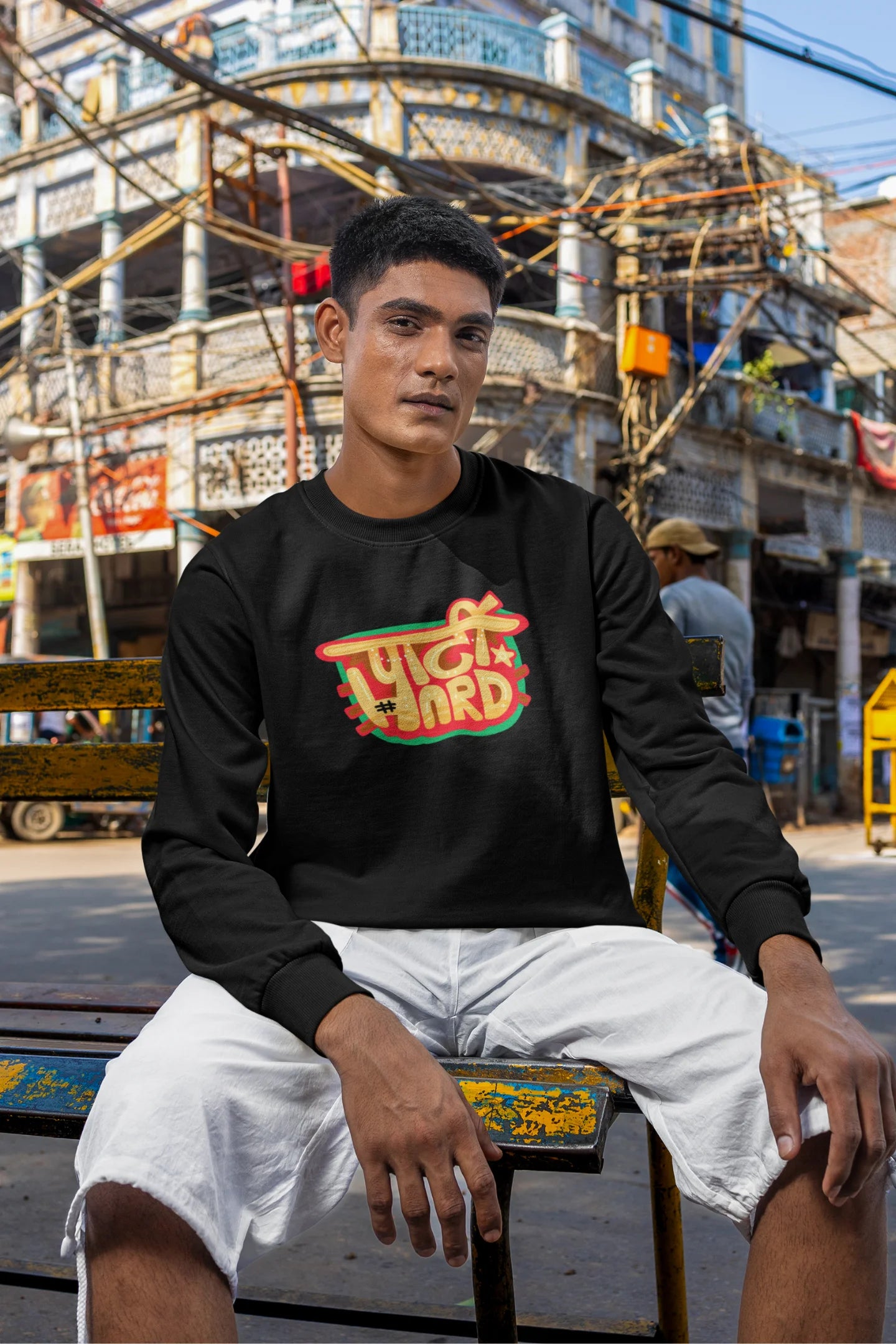 5th front view of a male model wearing a black oversized t-shirt with the phrase "Party Hard" in an energetic Hindi.