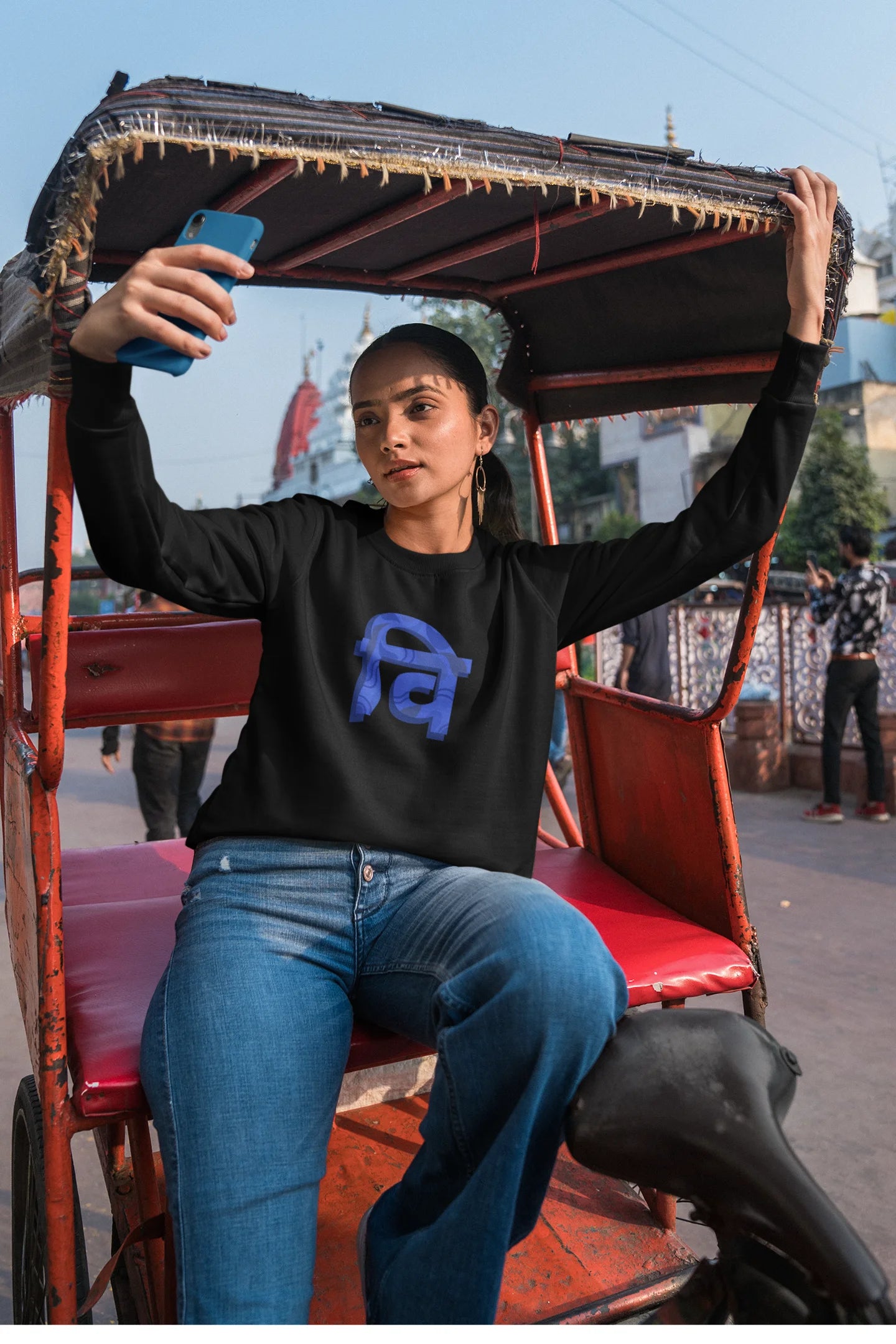 5th front view of a female model wearing a black sweatshirt with the phrase "Vichitra Pranee" (meaning "Strange being" or "alien") in a stylish Hindi font.