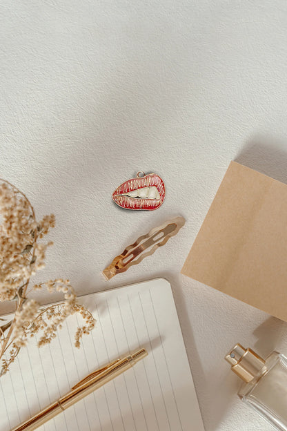Fourth image of an charm featuring the Taylor Swift phrase "You Owe Him Nothing" on a lip design. Perfect for all Swifties.