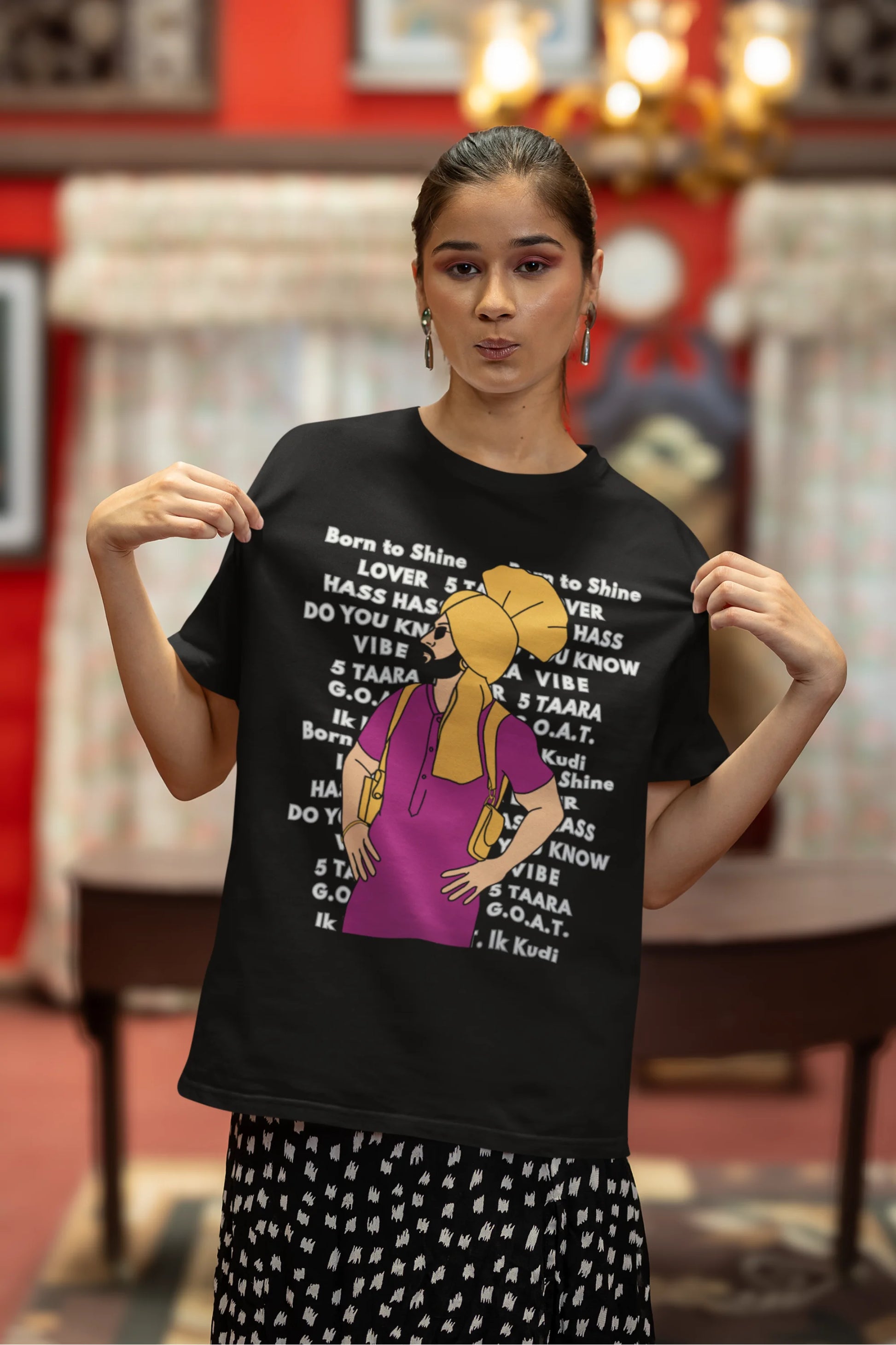 Third image of a female model wearing a black oversized t-shirt with a Diljit Dosanjh portrait on a t-shirt with his album titles written in the background.