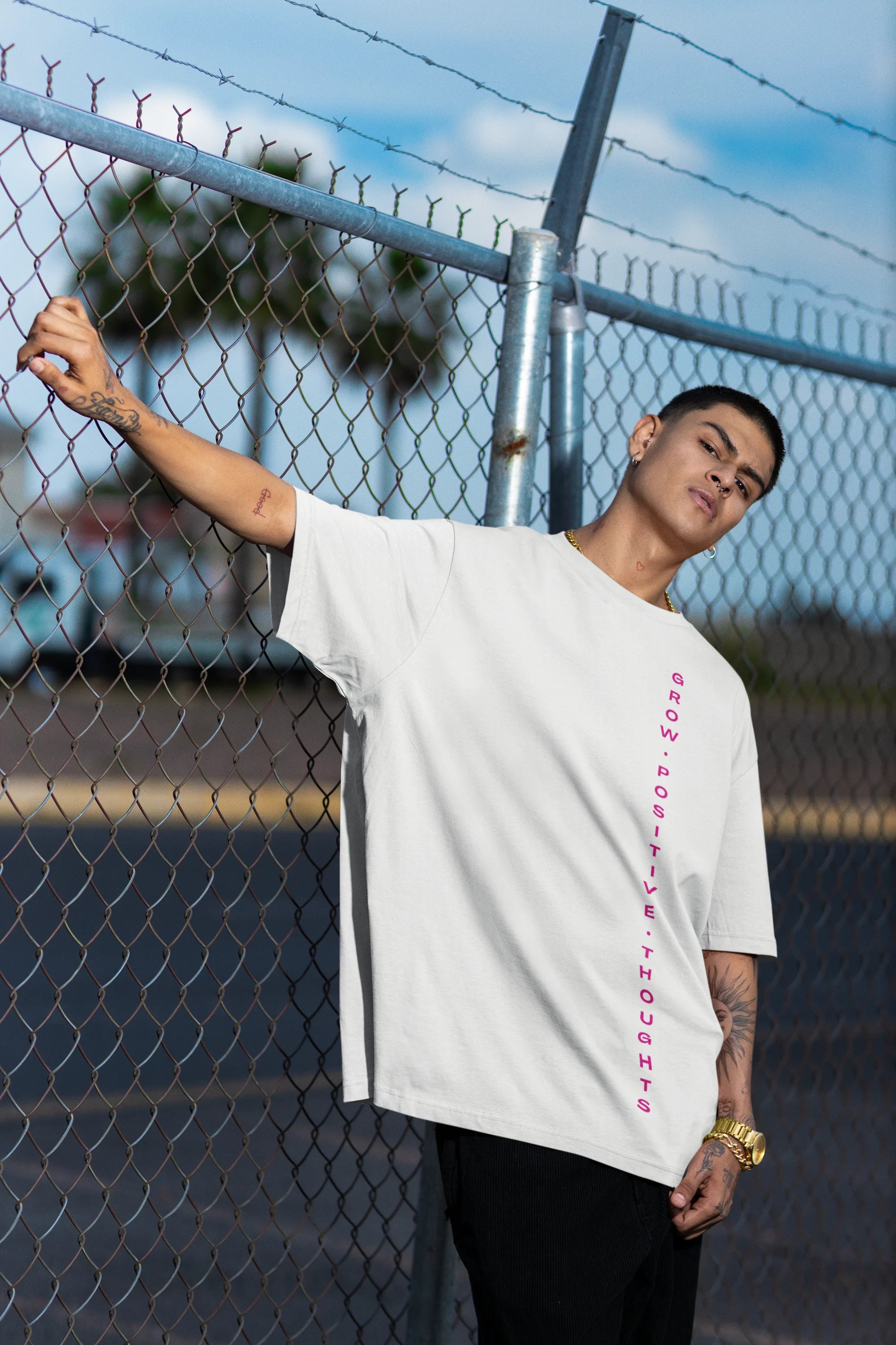 Side view of a male model wearing an off-white oversized t-shirt featuring a thought-provoking design of a man's bust with the text "Think It's Free of Cost." Ideal for those who love funny clothing and the importance of mindful communication.