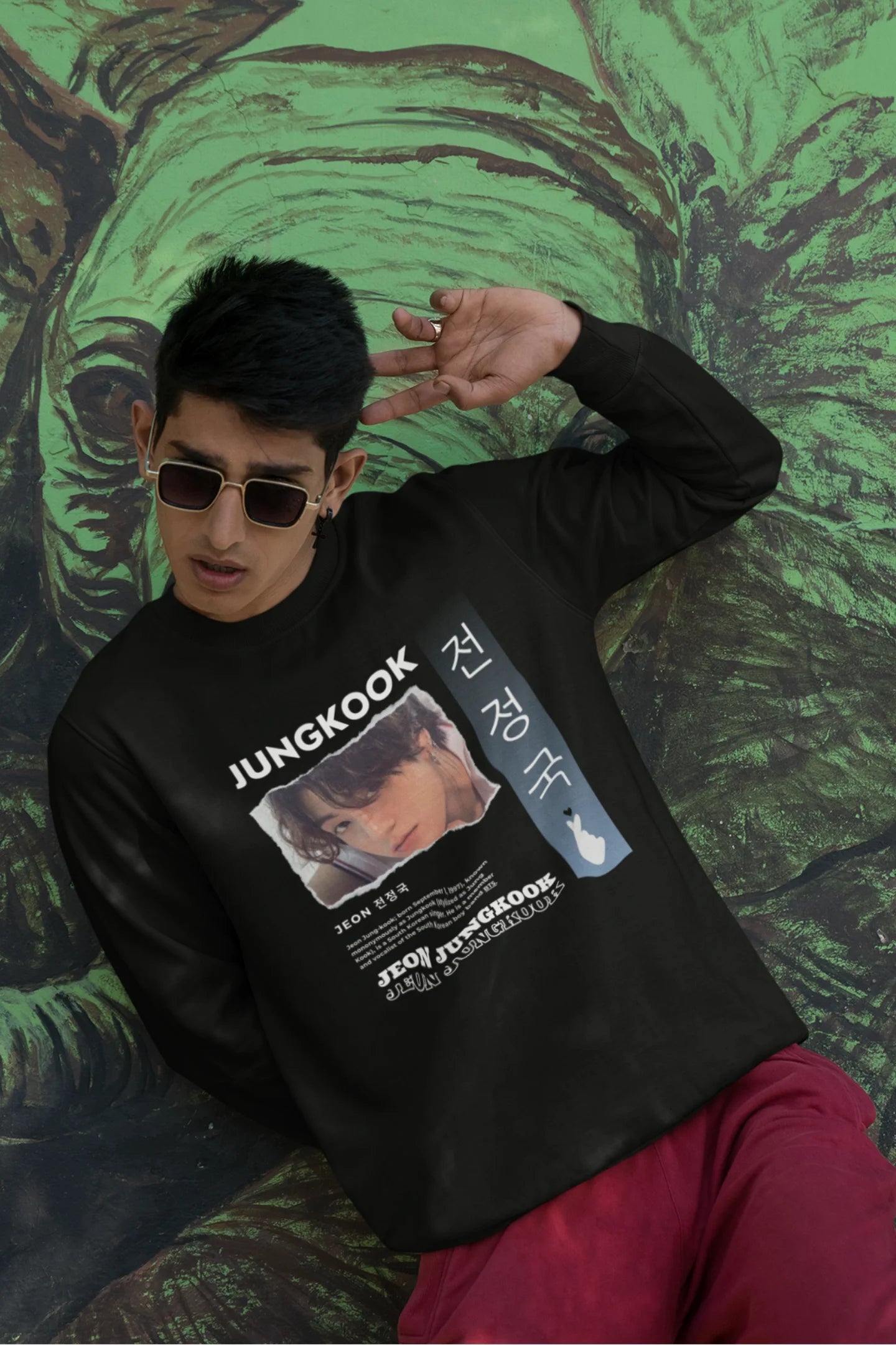 Third front view of a male model wearing a black sweatshirt featuring a vibrant design inspired by BTS member Jungkook. Ideal for fans of BTS and K-Pop music in general.