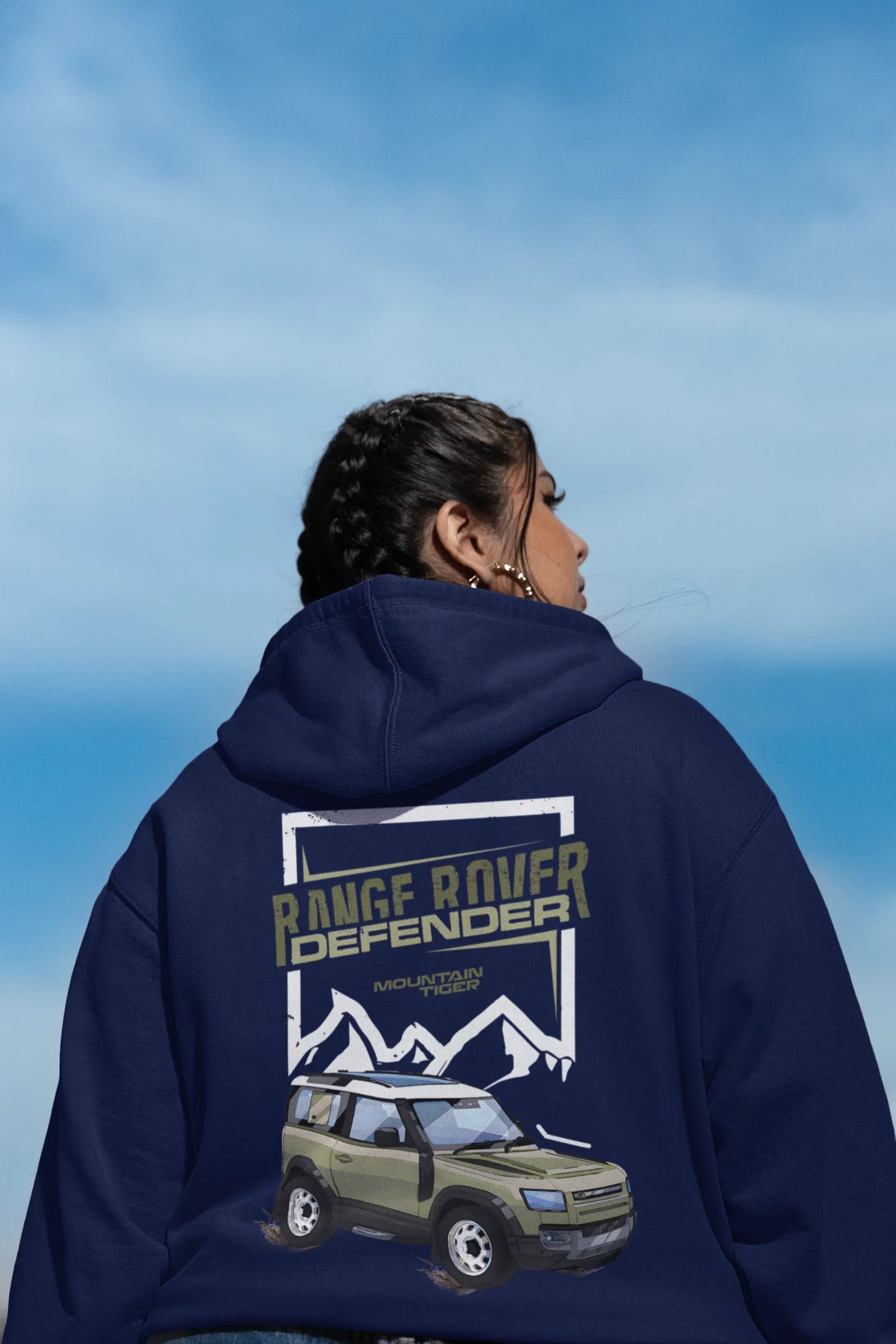 Back of a female model wearing a navy blue hoodie featuring a Range Rover Defender design, exuding power and ruggedness.