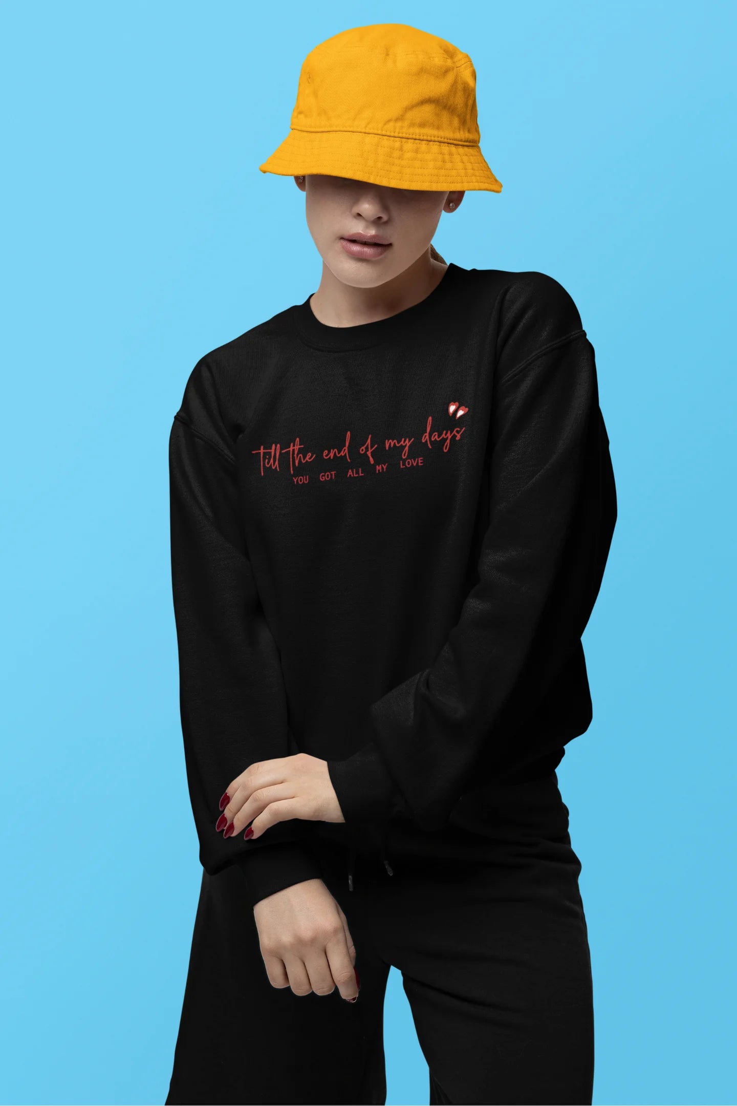 First front view of a female model wearing a black sweatshirt with a heart design and the text "All My Love".