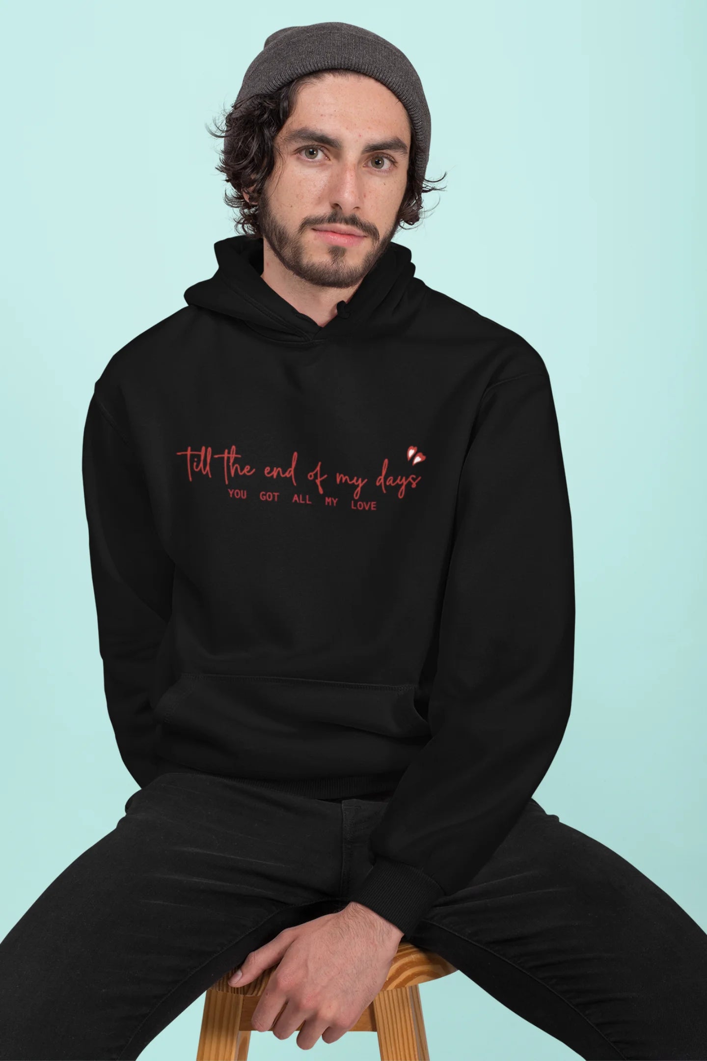 First front view of a male model wearing a black hoodie with a heart design and the text "All My Love".