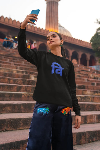 First front view of a female model wearing a black sweatshirt with the phrase "Vichitra Pranee" (meaning "Strange being" or "alien") in a stylish Hindi font.