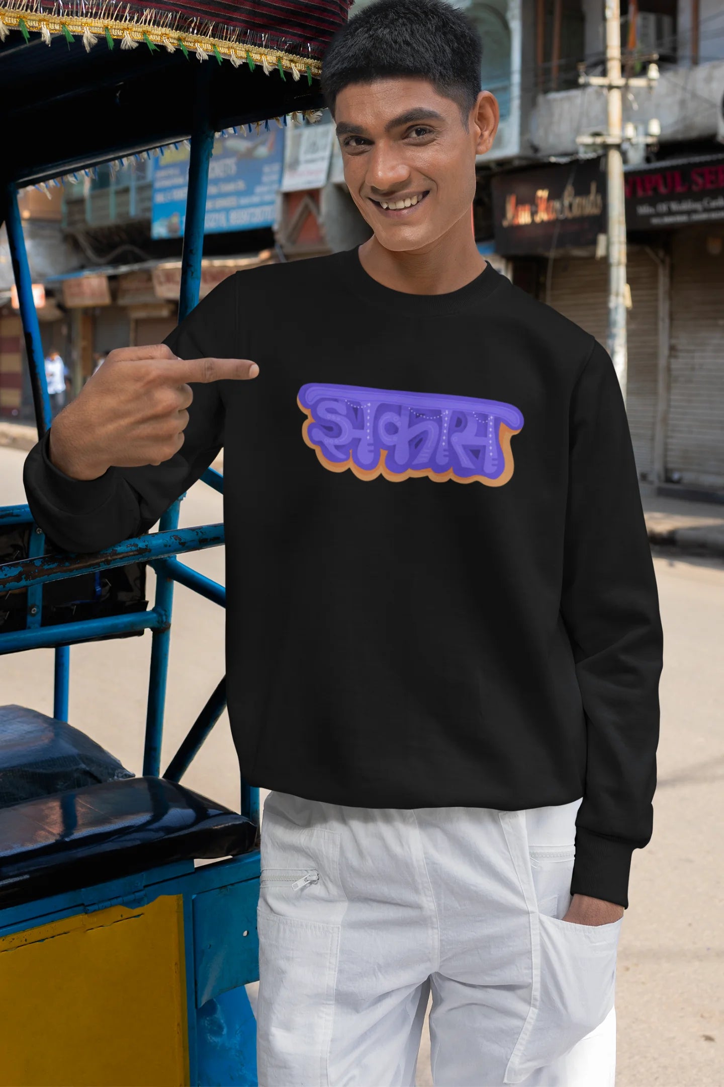 3rd front view of a male model wearing an black sweatshirt featuring "Jhakas" in a stylish font.