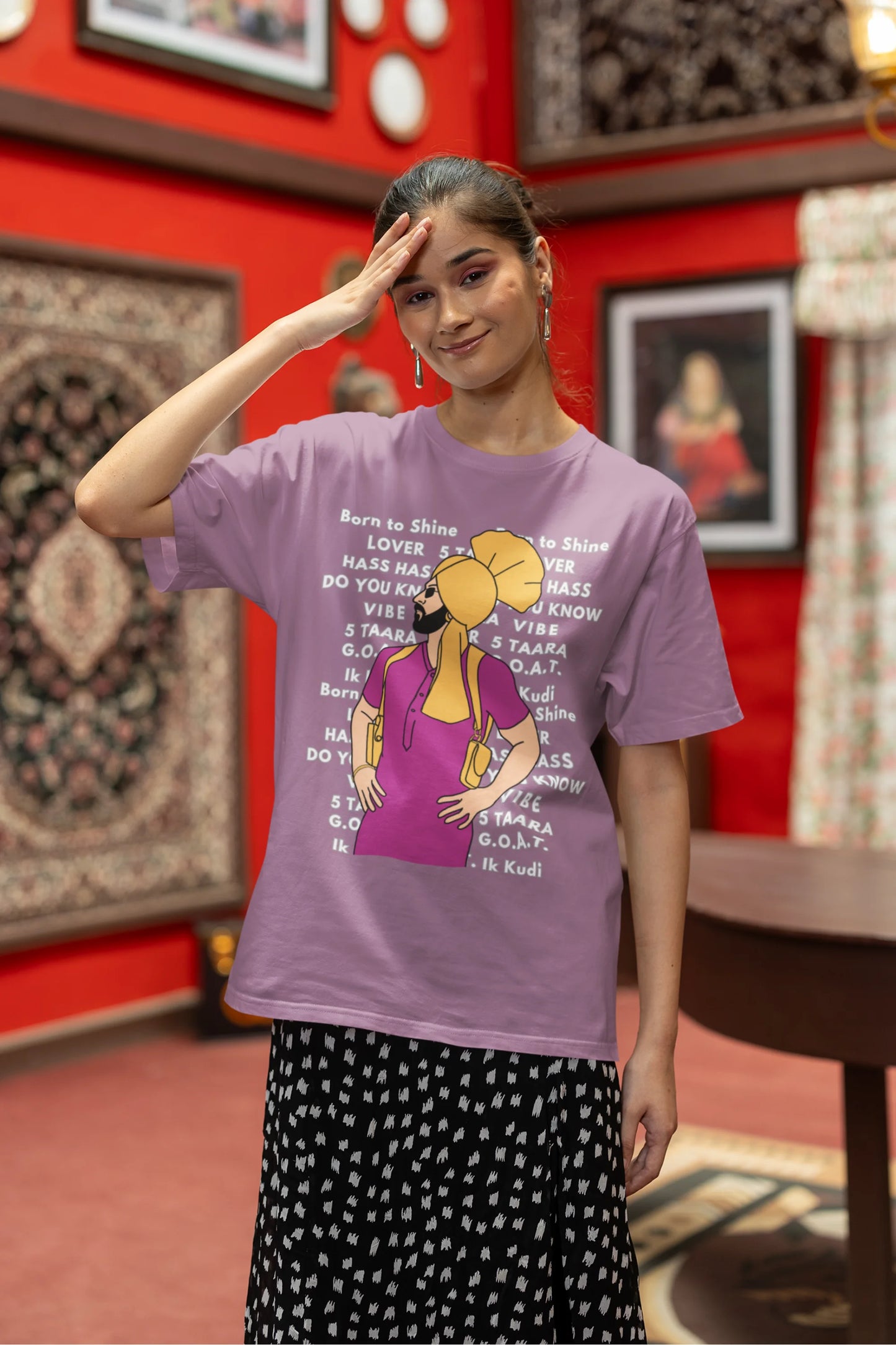 Second image of a female model wearing a dirty purple oversized t-shirt with a Diljit Dosanjh portrait on a t-shirt with his album titles written in the background.