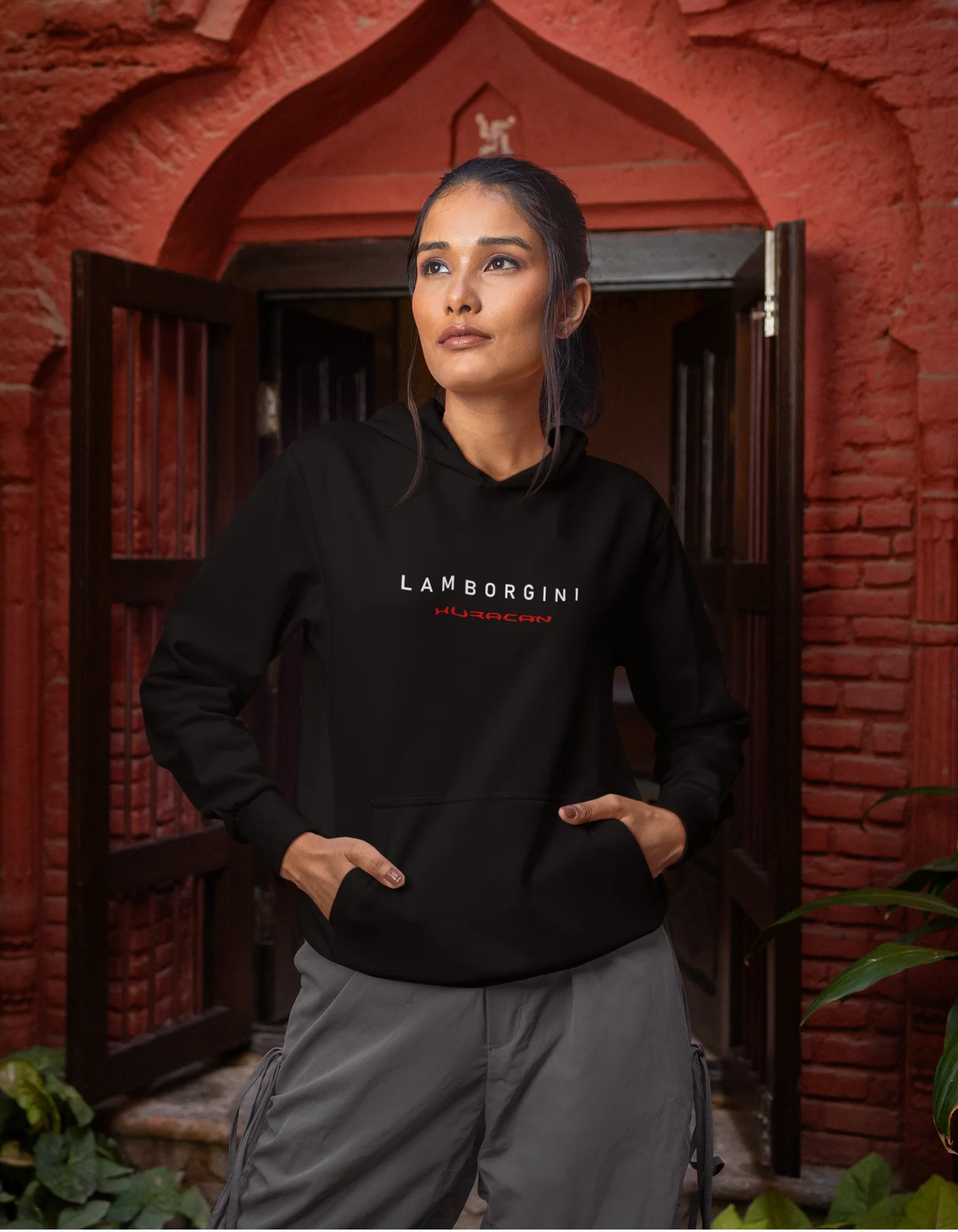 First front view of a female model wearing a black hoodie featuring a Lamborghini Huracan design, exuding speed and power.