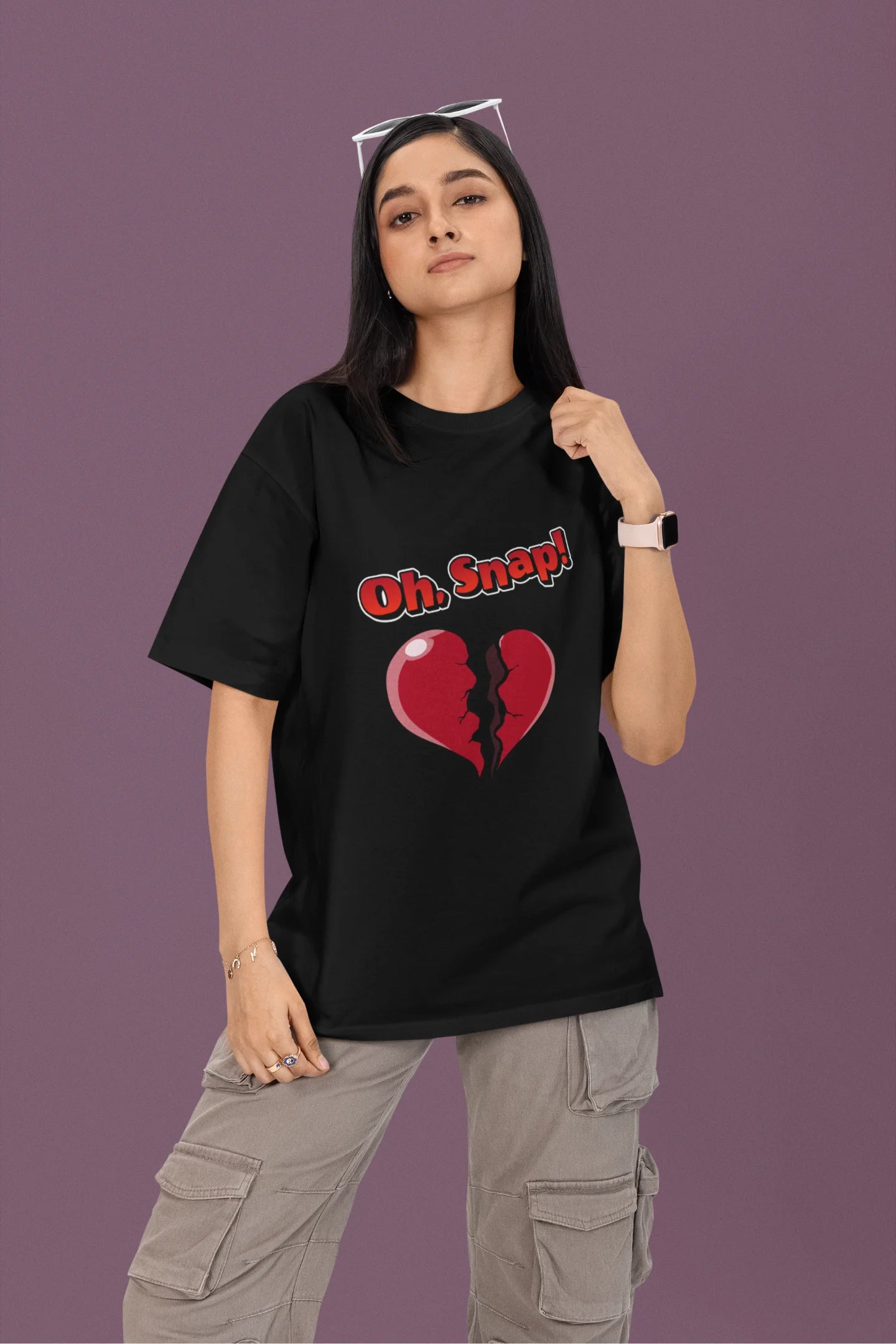 2nd front view of a female model wearing a black oversized t-shirt with the text "Oh Snap!" and a broken heart symbol underneath.