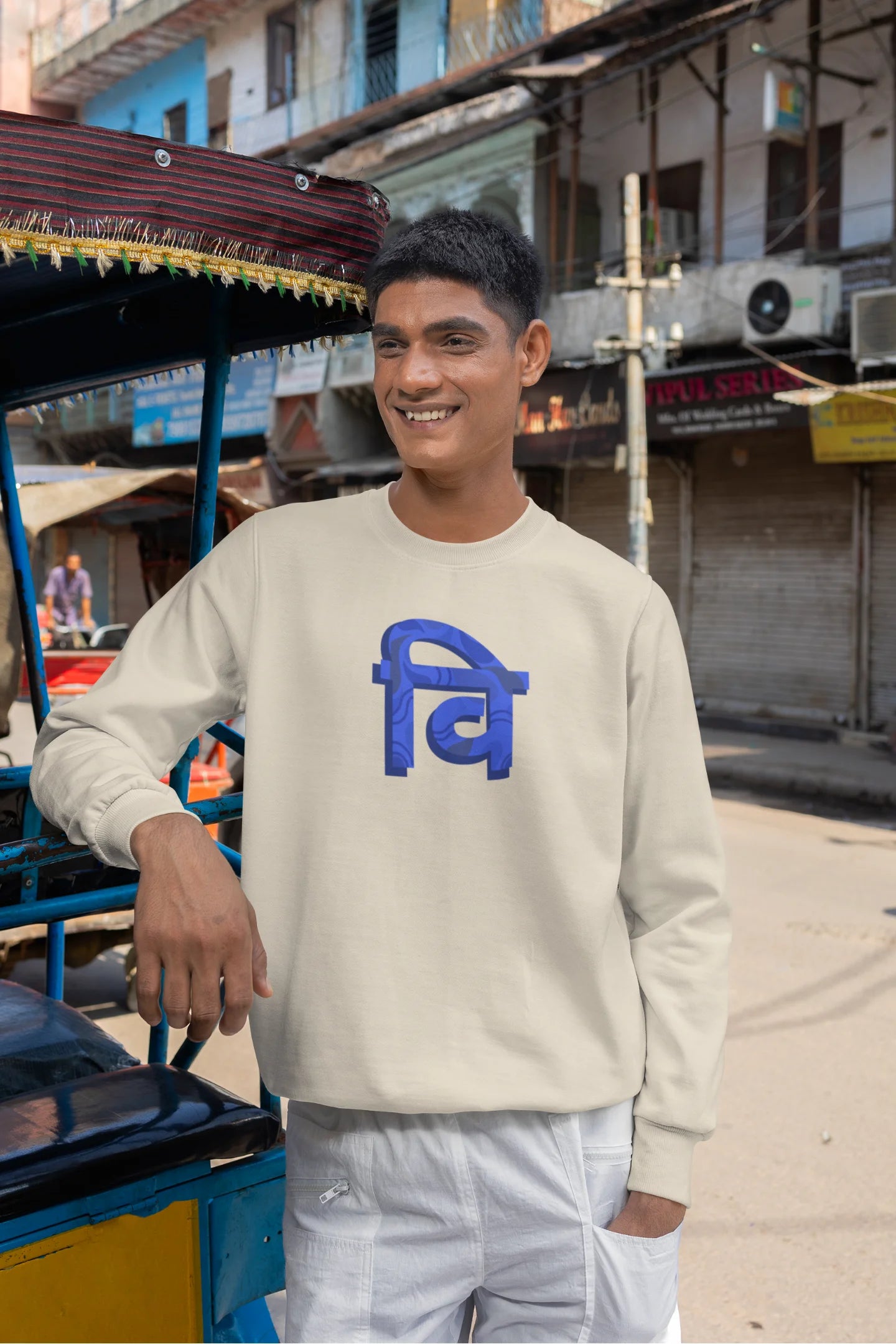 4th front view of a male model wearing a cream sweatshirt with the phrase "Vichitra Pranee" (meaning "Strange being" or "alien") in a stylish Hindi font.