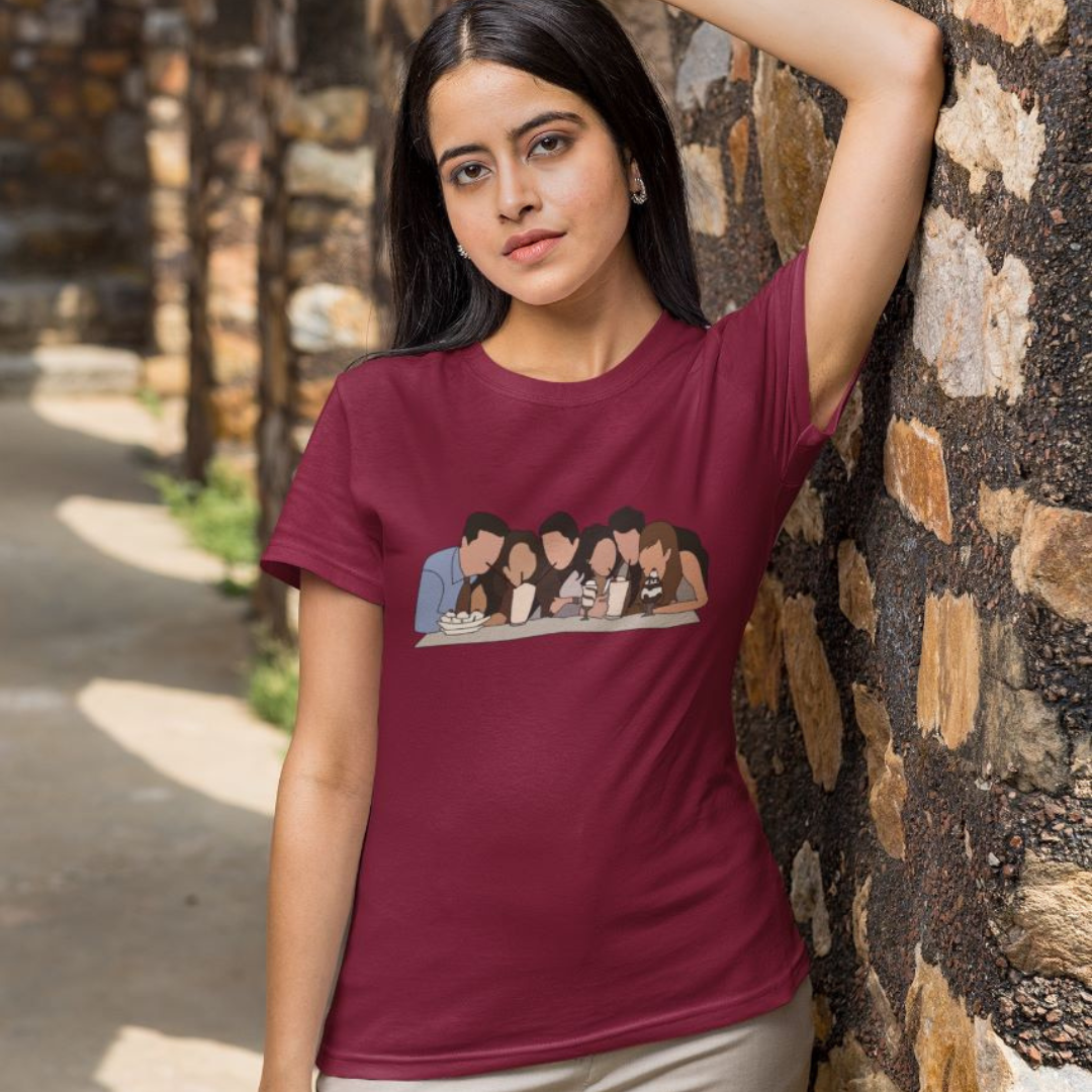Front view of a female model wearing a maroon casual tee with Friends TV show inspired design featuring the central perk crew.