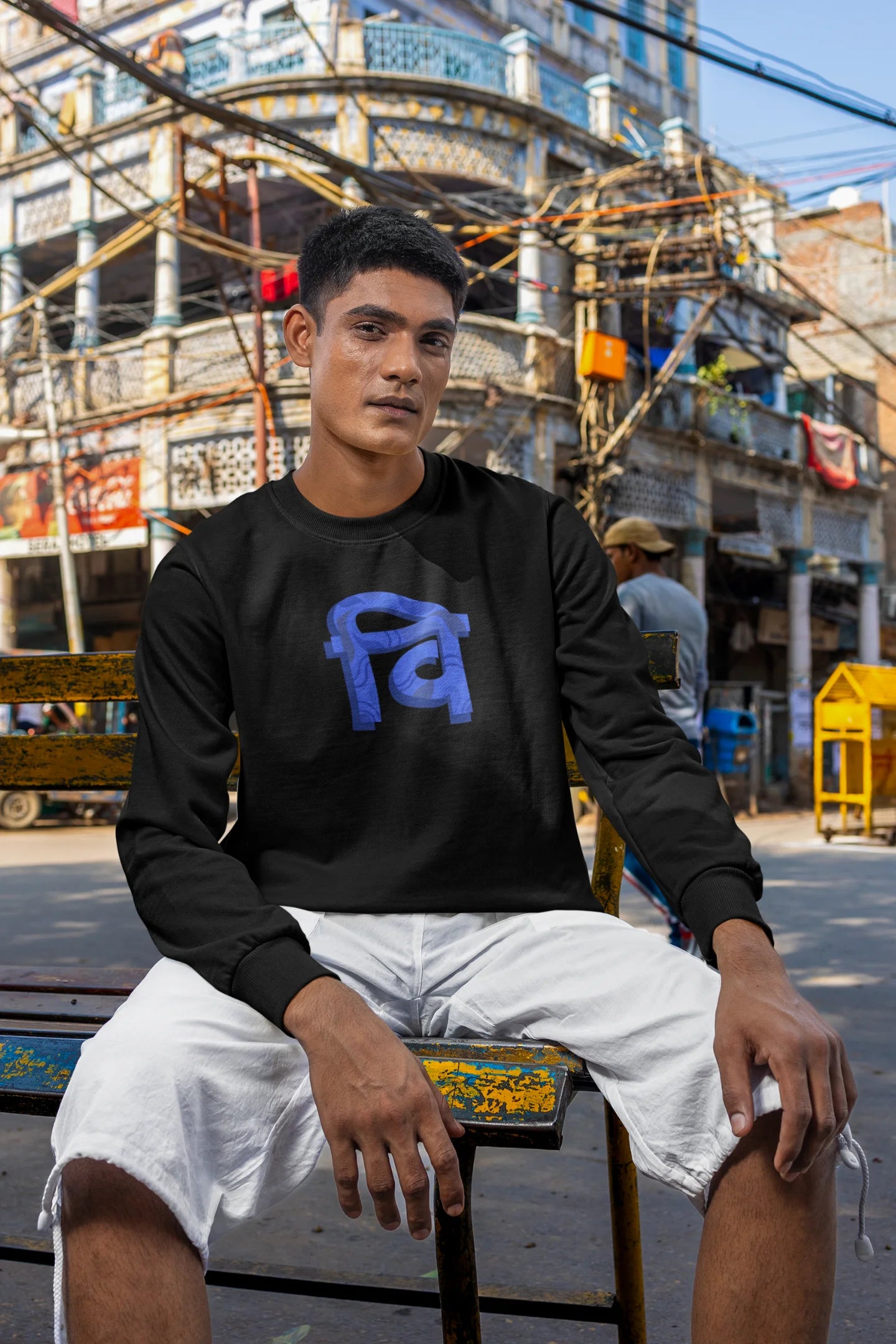 3rd front view of a male model wearing a black sweatshirt with the phrase "Vichitra Pranee" (meaning "Strange being" or "alien") in a stylish Hindi font.