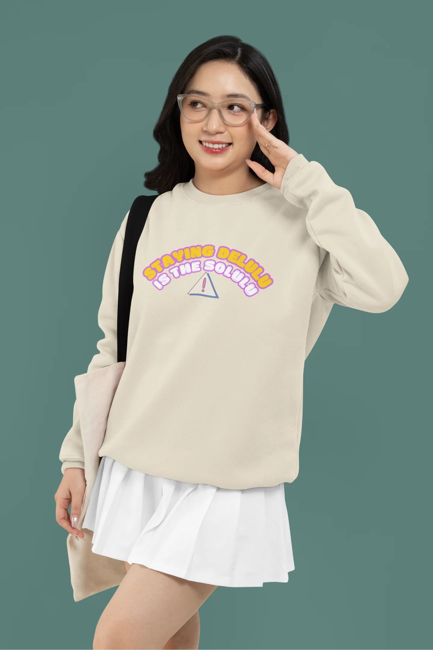 4th front view of female model wearing a cream sweatshirt with the hilarious message "Stay Delulu" in a bold design. Ideal for those who love trendy slang and lighthearted humor.