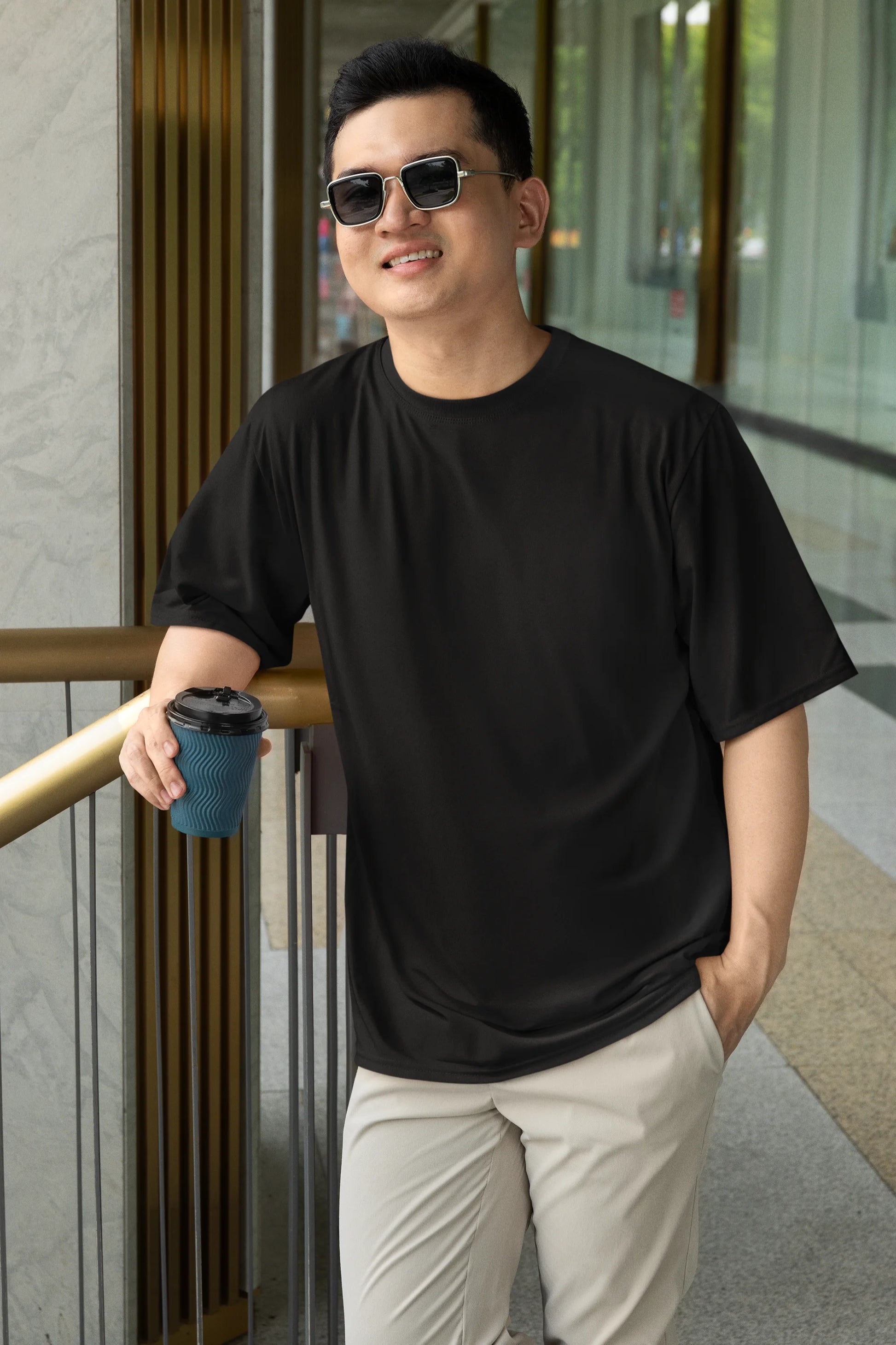 Front view of a male model wearing a black oversized tee with a design of a fox and its cub in a traditional Japanese landscape.