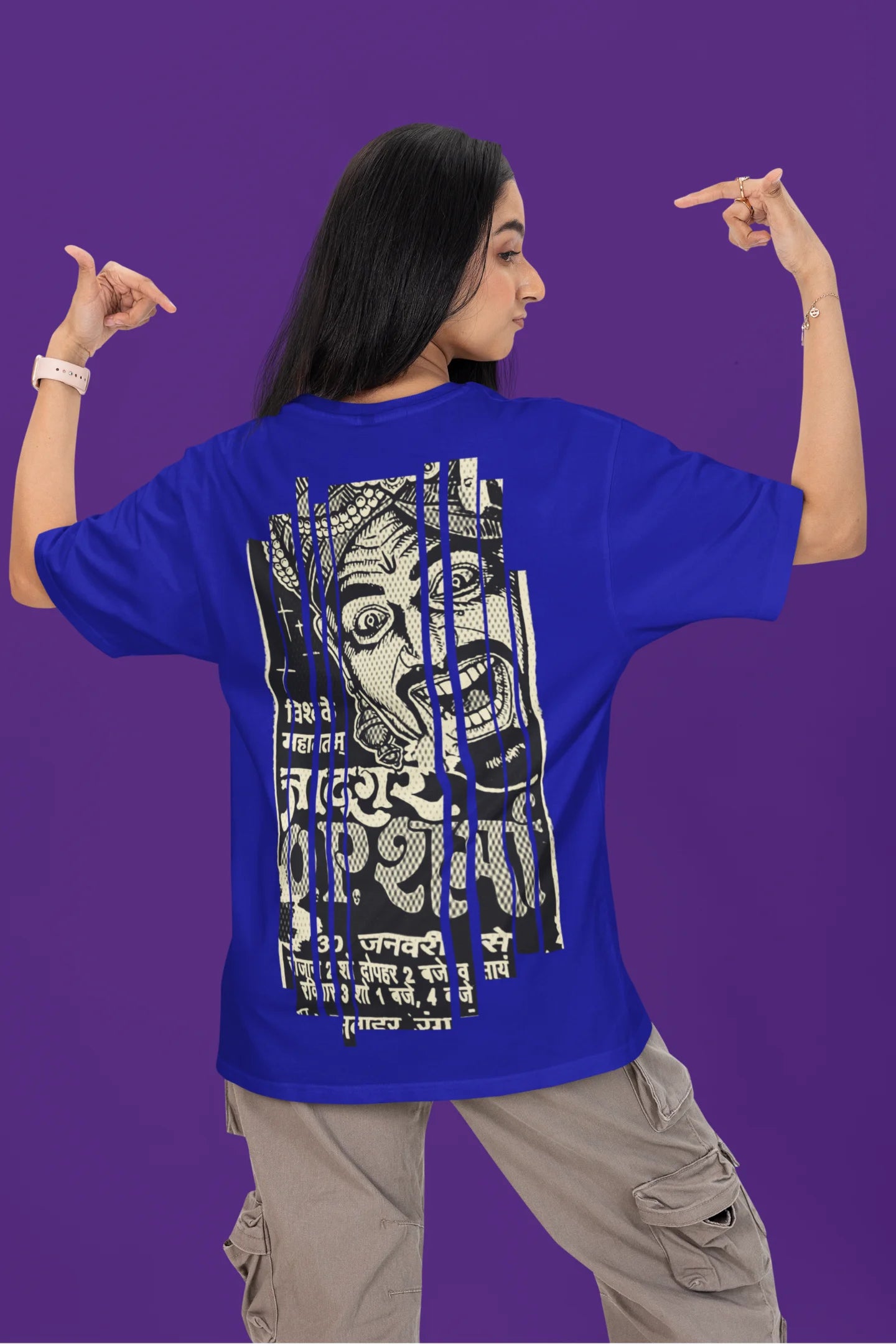 Back view of a female model wearing a royal blue oversized t-shirt with a design referencing "Bachpan" (childhood) and featuring a recognizable element or silhouette associated with the Indian magician "O P Sharma."