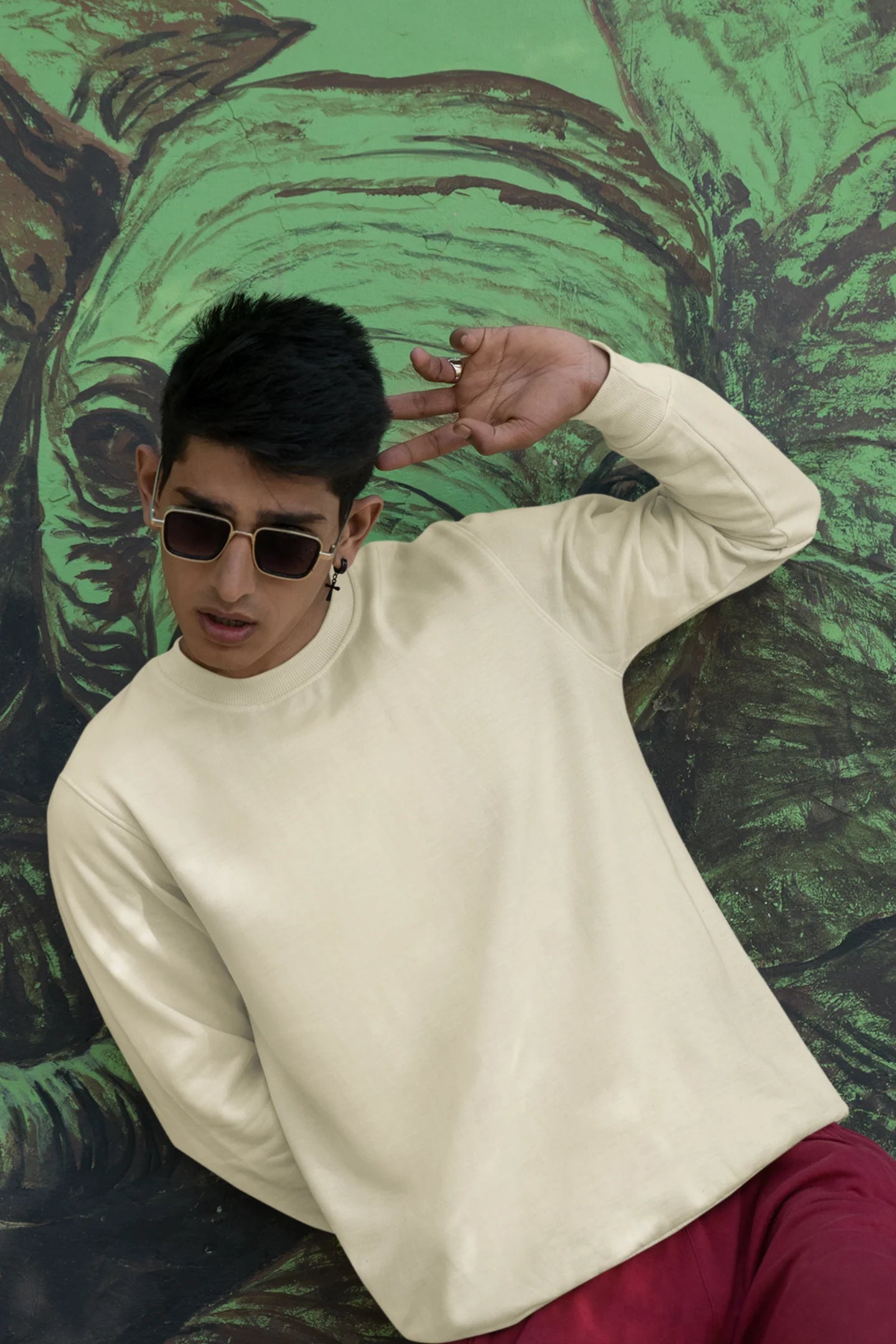 Third front view of male model wearing a cream F.R.I.E.N.D.S. sweatshirt featuring a design inspired by Joey Tribbiani's funny quotes and signature charm.