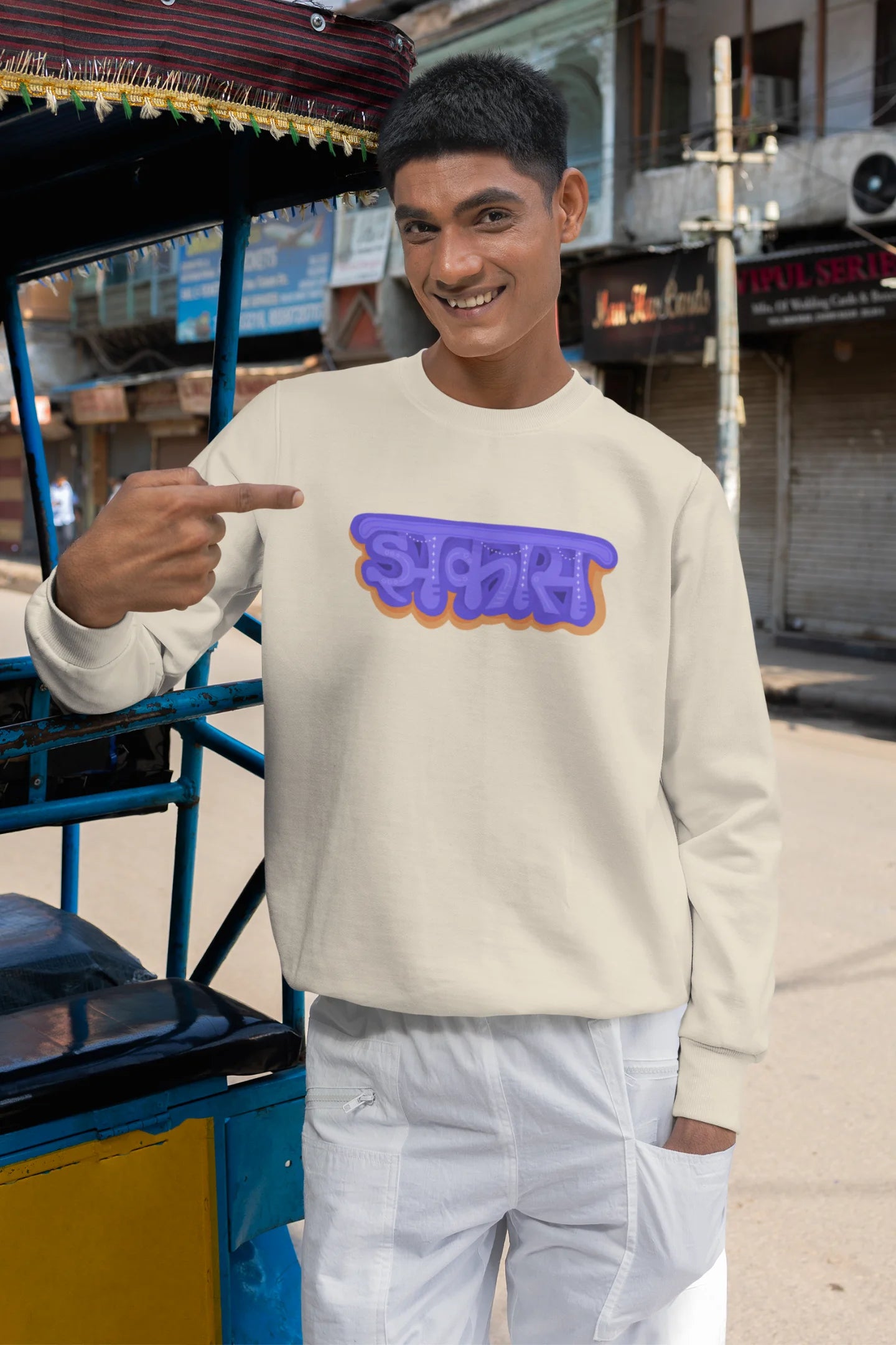 4th front view of a male model wearing an cream sweatshirt featuring "Jhakas" in a stylish font.