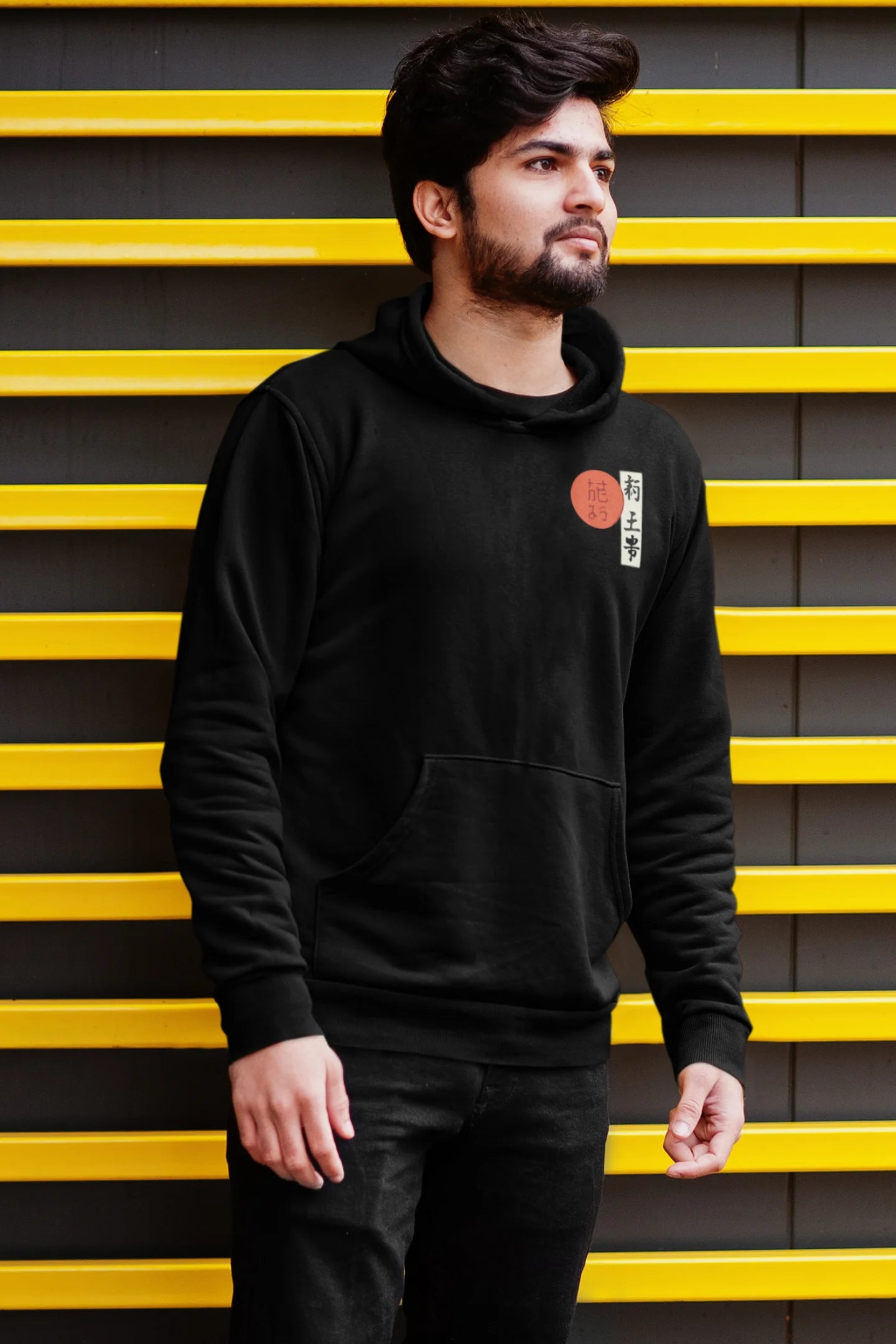 First front view of a male model wearing a black hoodie with a design of a wolf surveying a Japanese landscape.