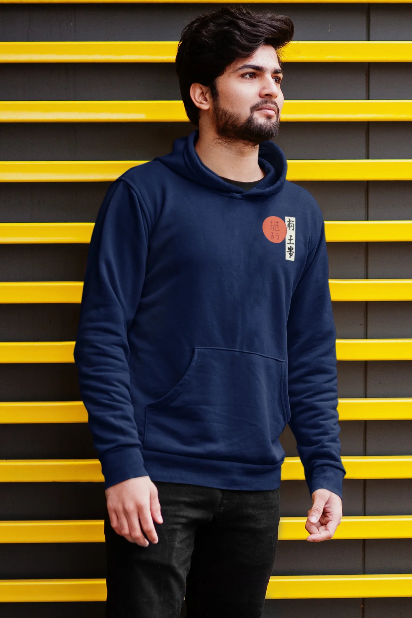Second front view of a male model wearing a navy blue hoodie with a design of a wolf surveying a Japanese landscape.
