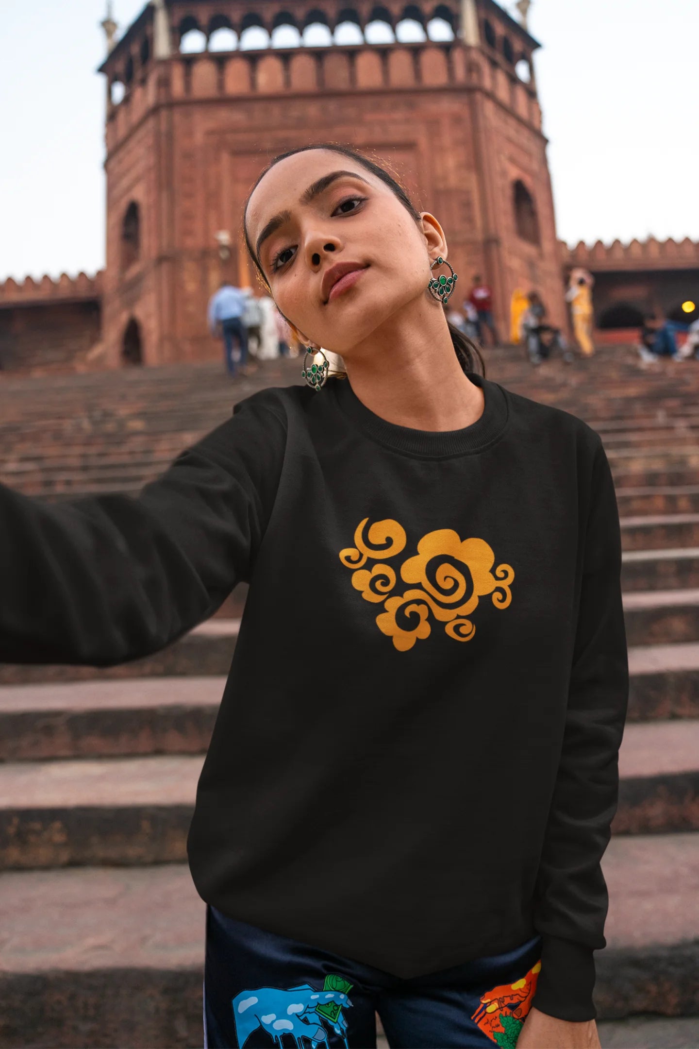 2nd front view of a female model wearing a black sweatshirt featuring "Bindass" in a stylish Hindi font.