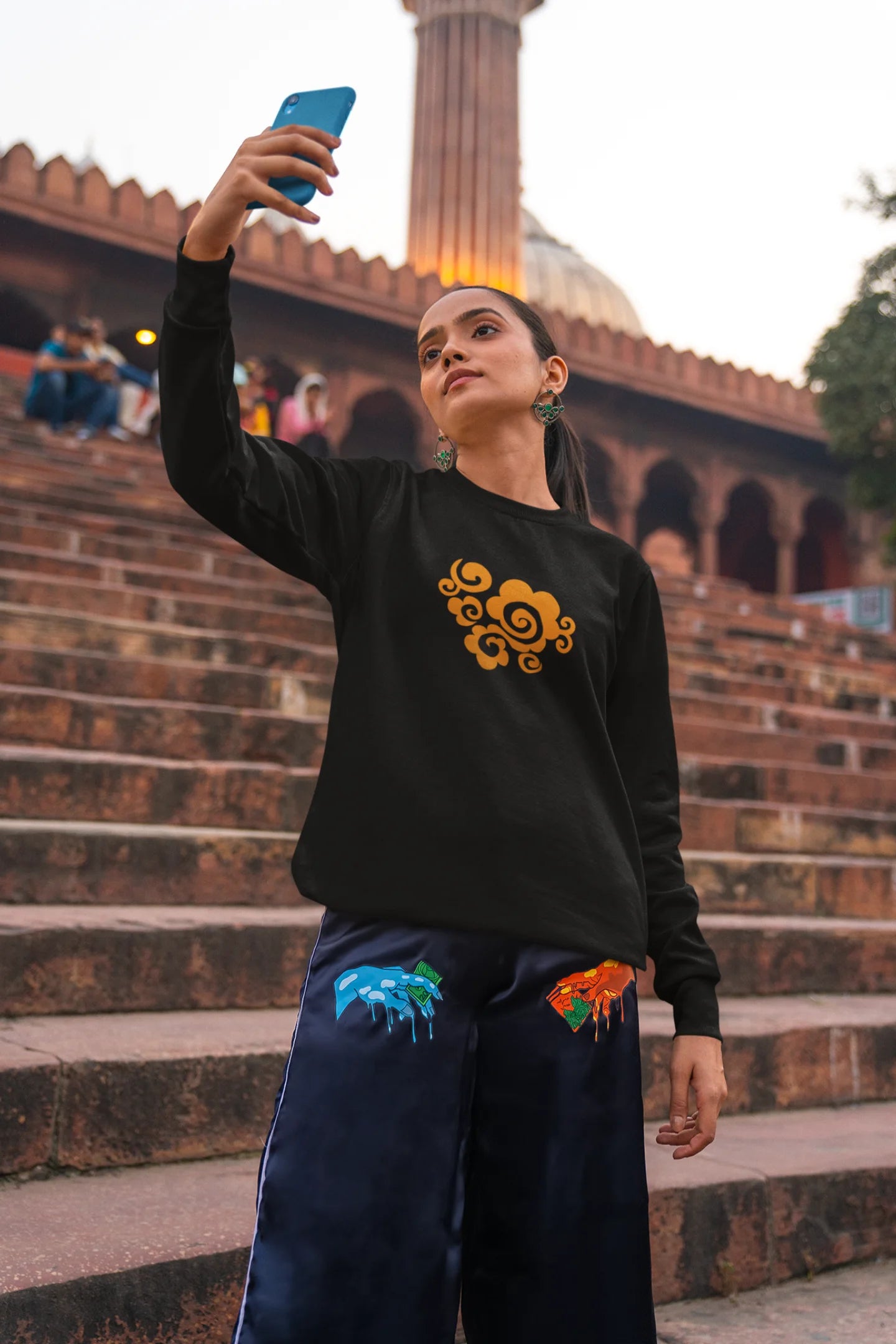 3rd front view of a female model wearing a black sweatshirt featuring "Bindass" in a stylish Hindi font.