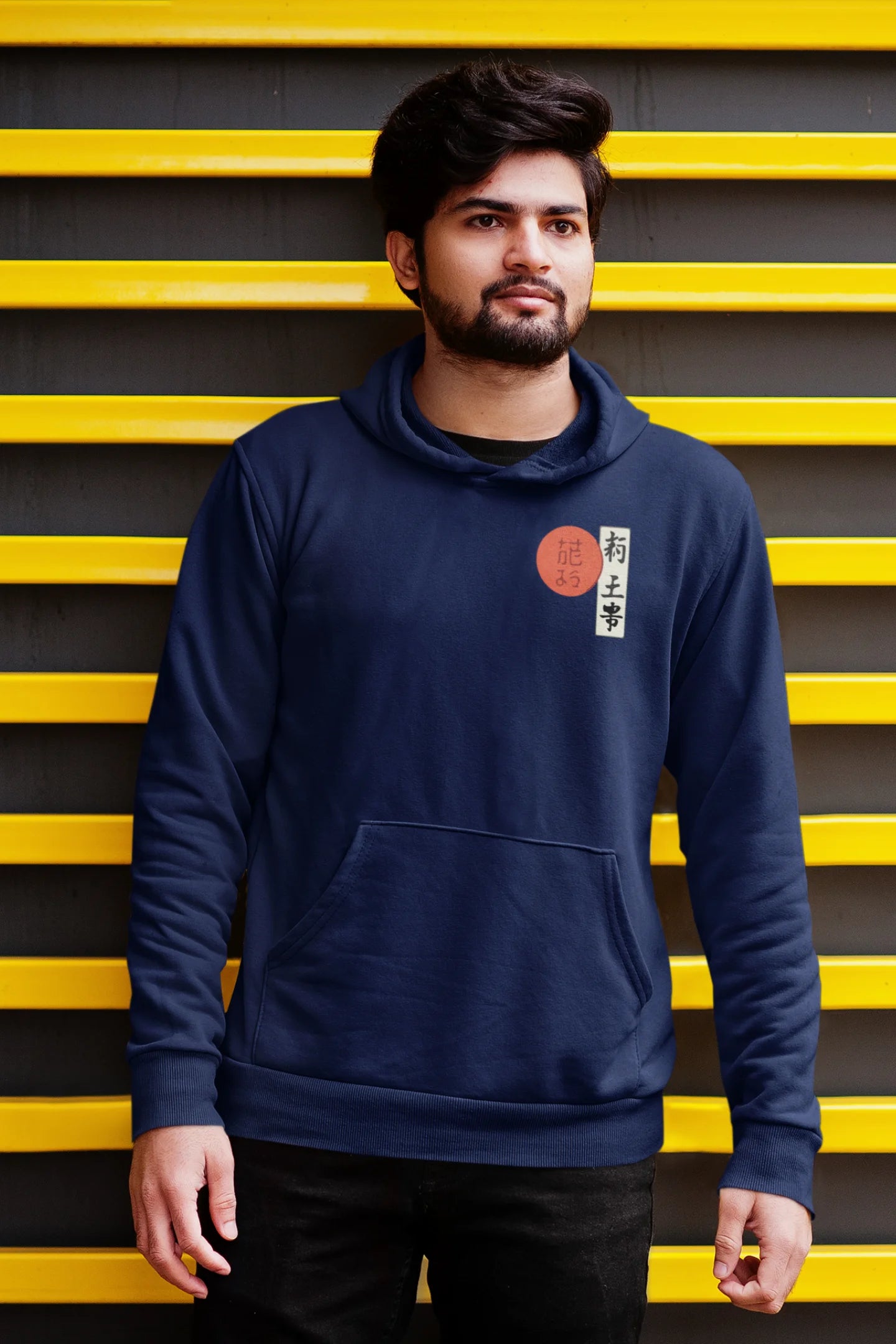 Third front view of a male model wearing a navy blue hoodie with a design of a wolf surveying a Japanese landscape.
