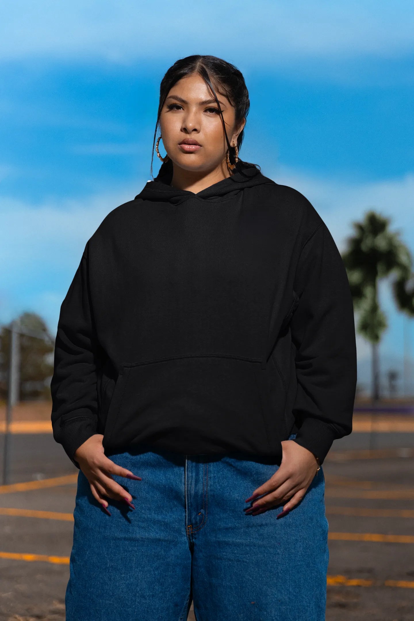First front of a female model wearing a black hoodie featuring a Range Rover Defender design, exuding power and ruggedness.