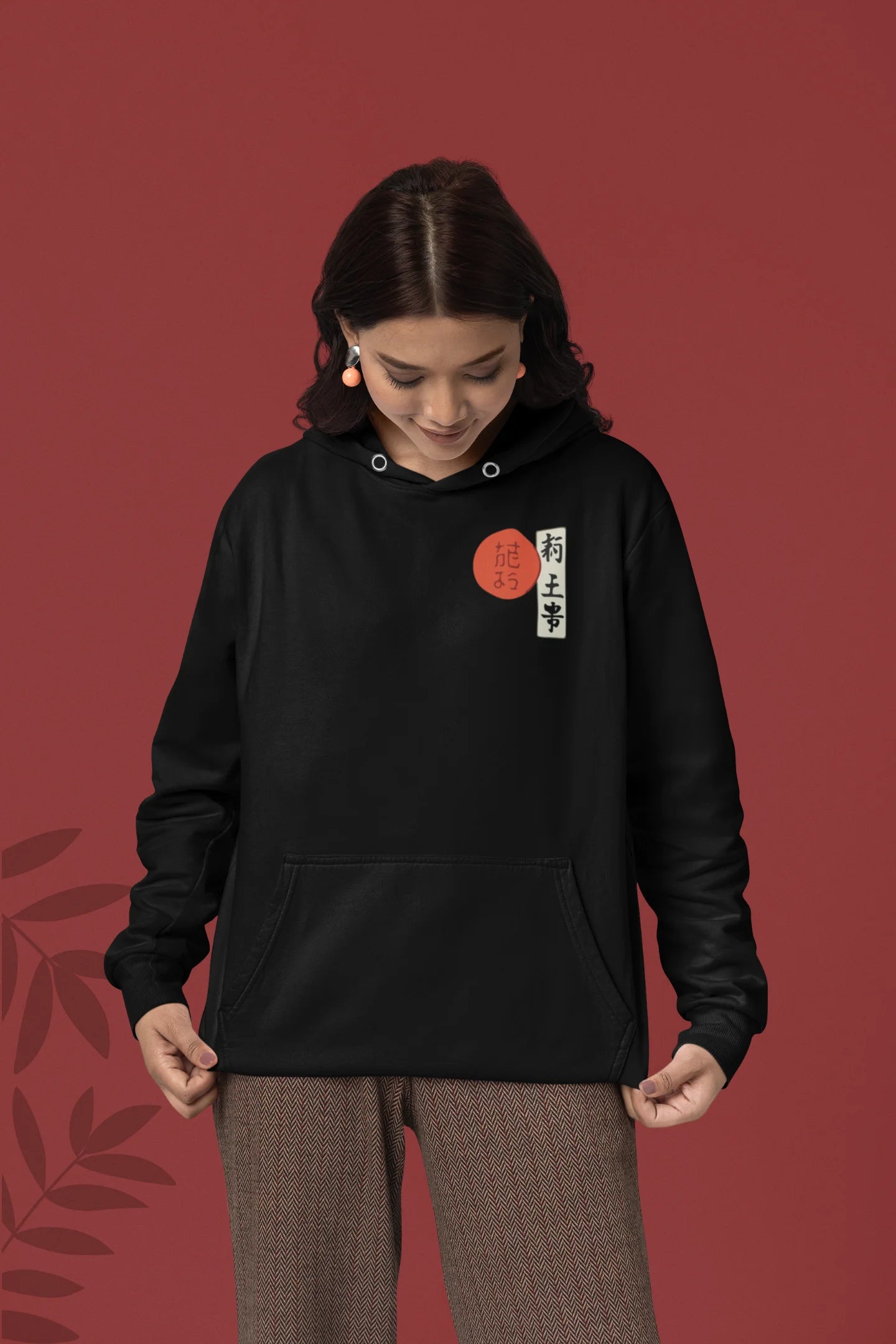 First front view of a female model wearing a black hoodie with a design of a wolf surveying a Japanese landscape.