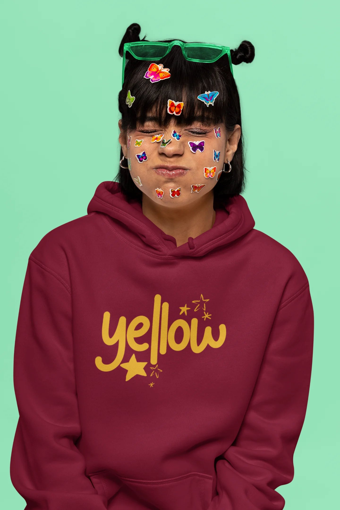 6th front view of a female model wearing a maroon hoodie with the "Yellow" album artwork by Coldplay.