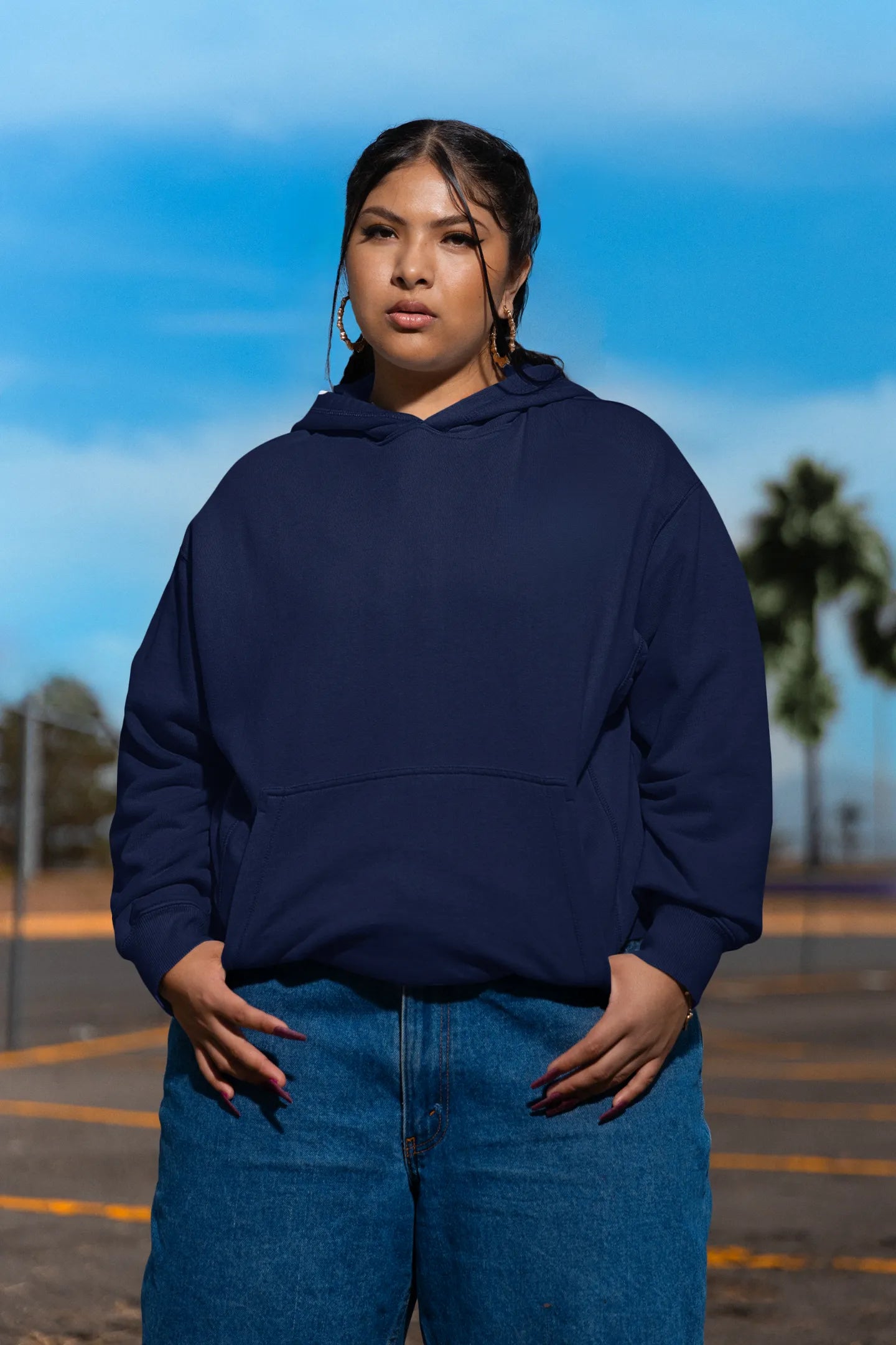 First front of a female model wearing a navy blue hoodie featuring a Range Rover Defender design, exuding power and ruggedness.