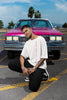 Front view of a male model wearing an off-white oversized t-shirt featuring a thought-provoking design of a man's bust with the text 