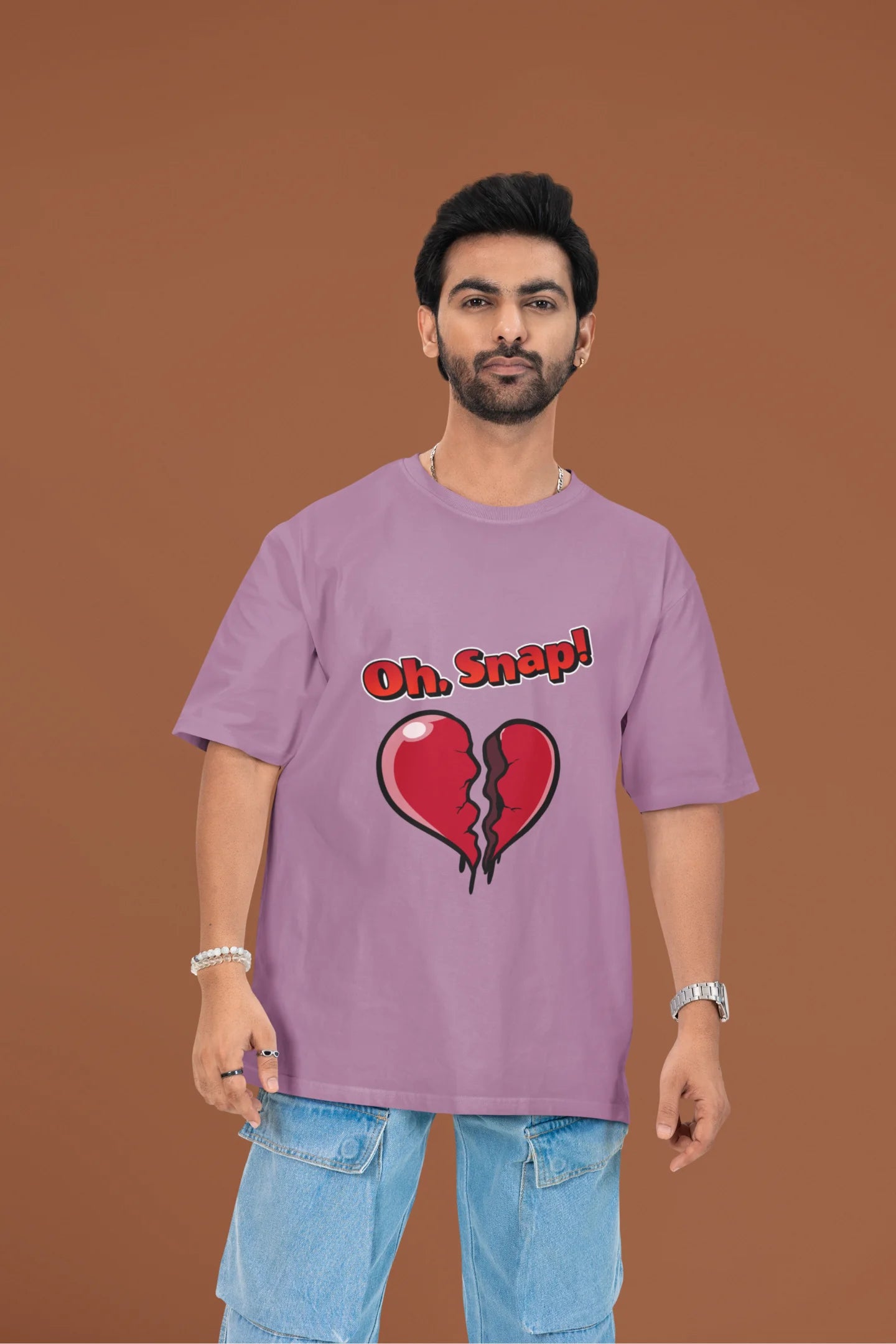 3rd front view of a male model wearing a dirty purple oversized t-shirt with the text "Oh Snap!" and a broken heart symbol underneath.