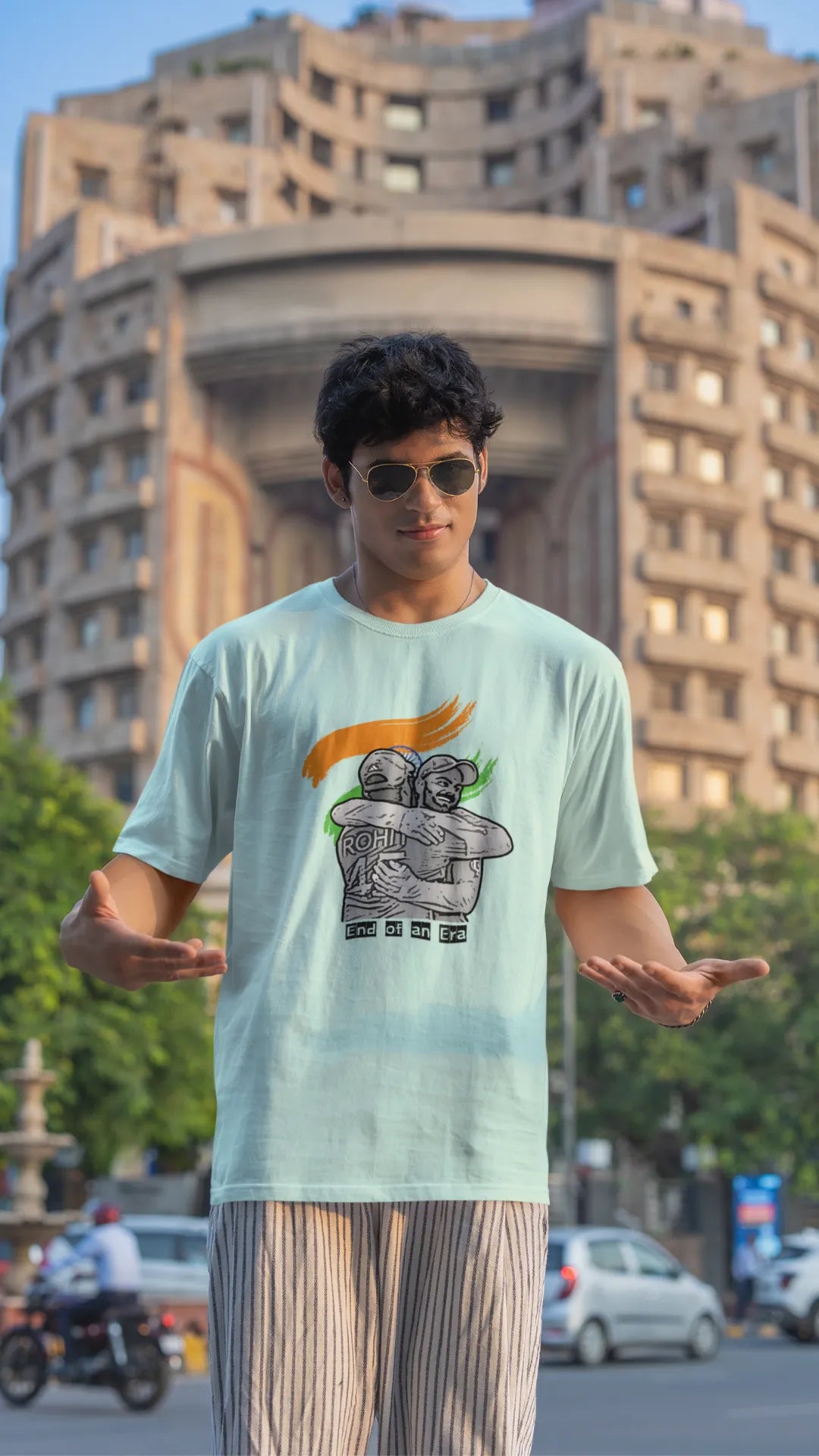 Third front view of a male model wearing an mint green oversized t-shirt featuring a photo of Virat Kohli and Rohit Sharma in a celebratory hug after the World Cup 2024 final. Ideal for Indian cricket fans who want to honor the team's victory and potentially a changing of the guard.