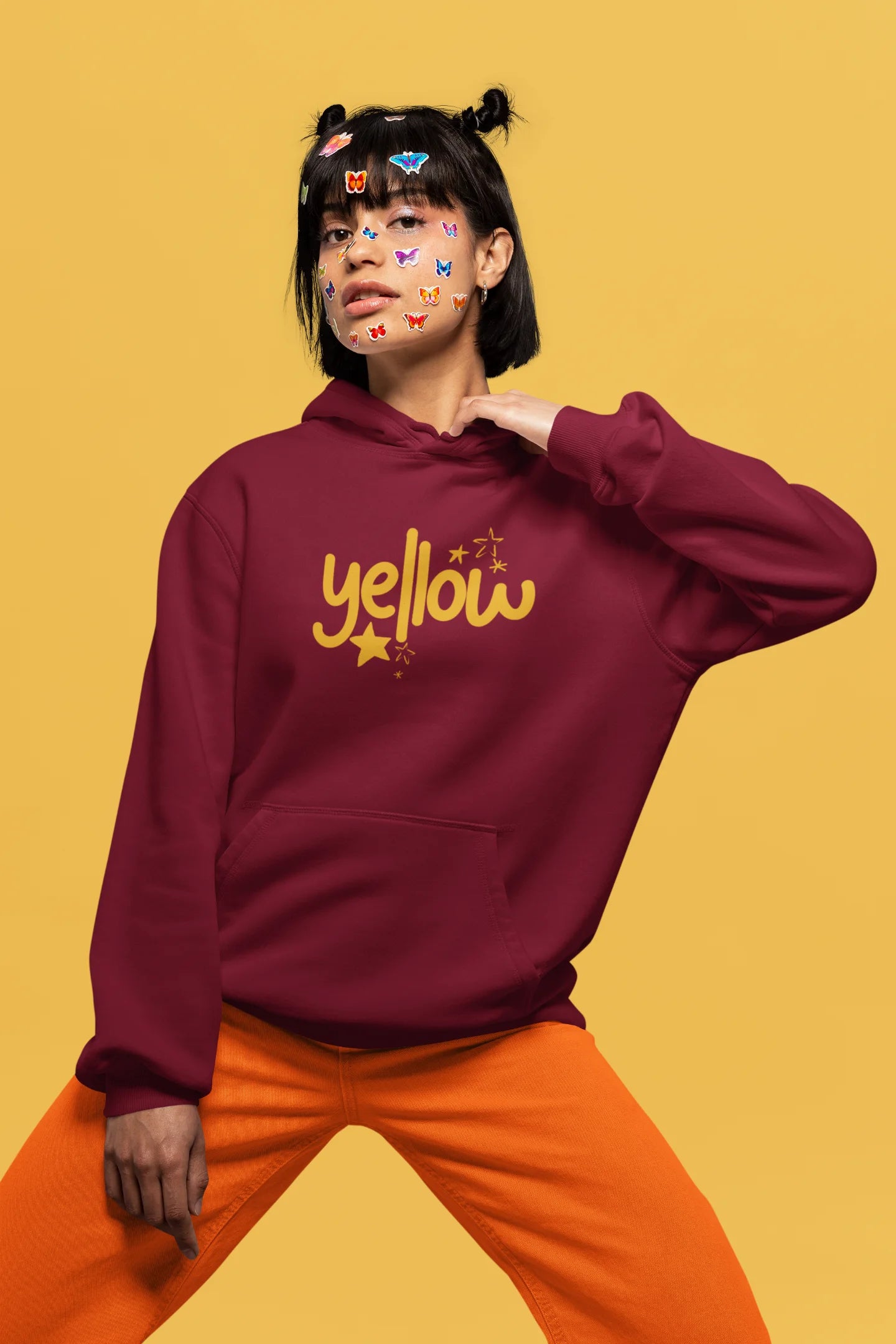 4th front view of a female model wearing a maroon hoodie with the "Yellow" album artwork by Coldplay.