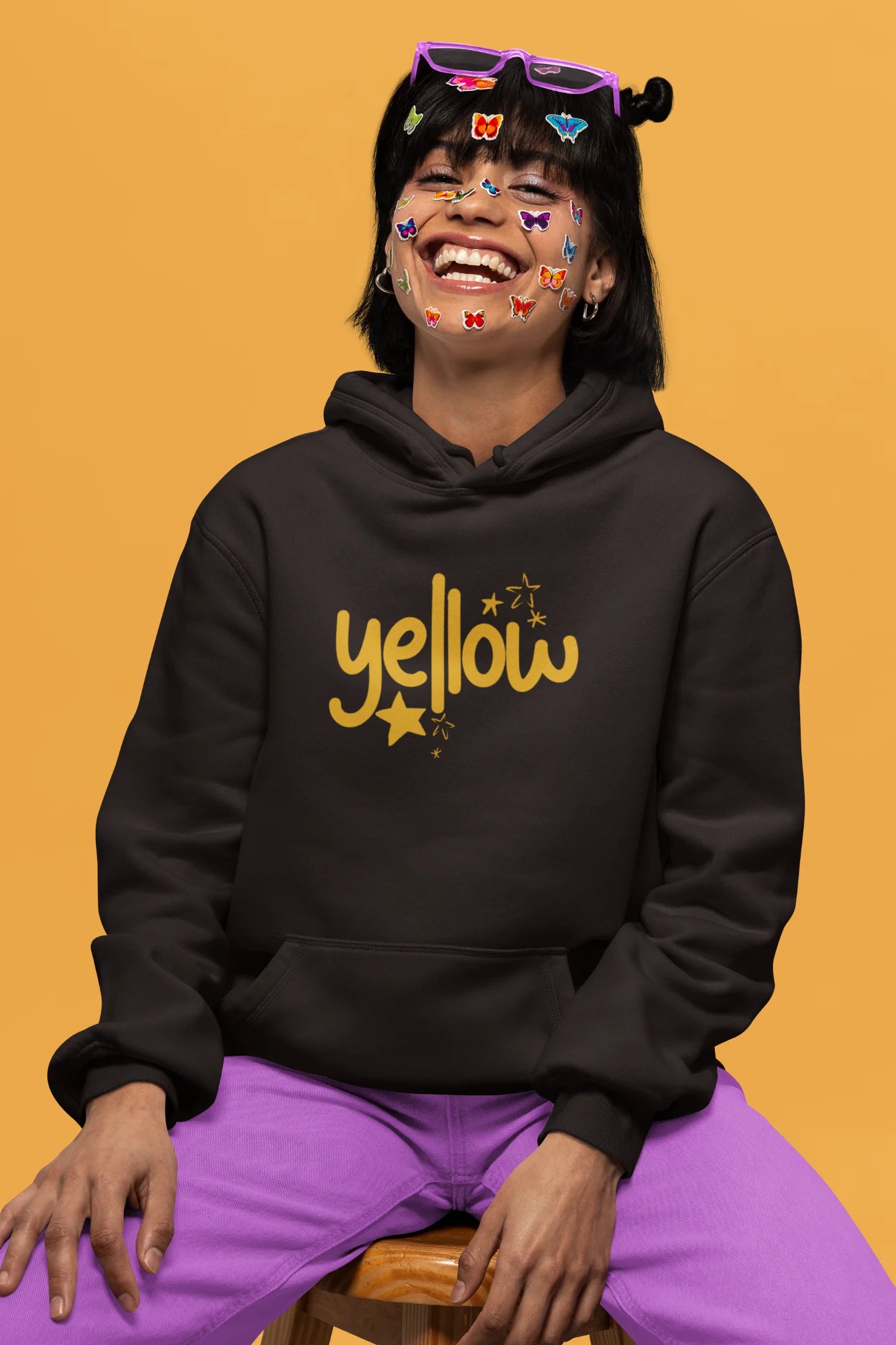 2nd front view of a female model wearing a chocolate brown hoodie with the "Yellow" album artwork by Coldplay.
