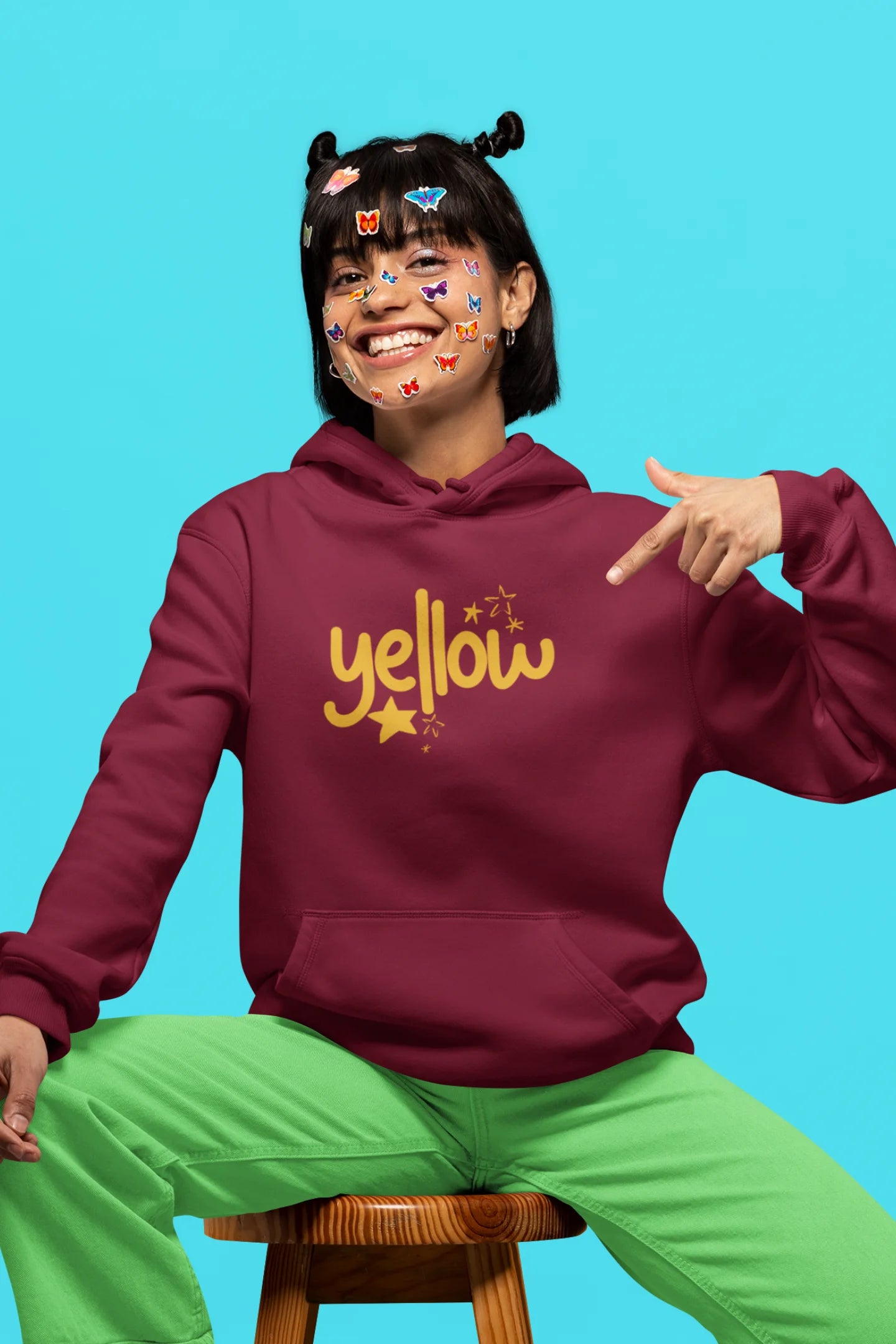 2nd front view of a female model wearing a maroon hoodie with the "Yellow" album artwork by Coldplay.