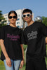 Second front view of a couple wearing matching black oversize tees, one with 