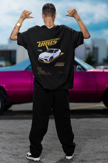 Back view of a male model wearing a black oversized t-shirt featuring a design of a Lamborghini Urus.