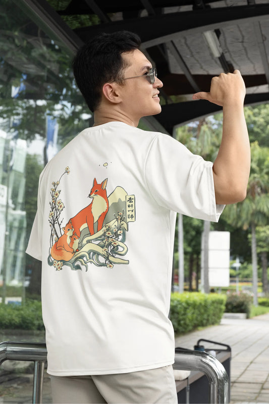 First back view of a male model wearing a off-white oversized tee with a design of a fox and its cub in a traditional Japanese landscape.