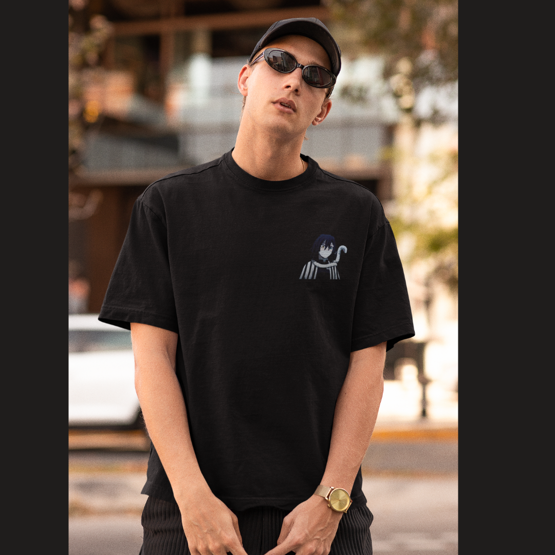 Front view of a male model wearing a black oversized t-shirt featuring Obanai Iguro from Demon Slayer: Kimetsu no Yaiba.