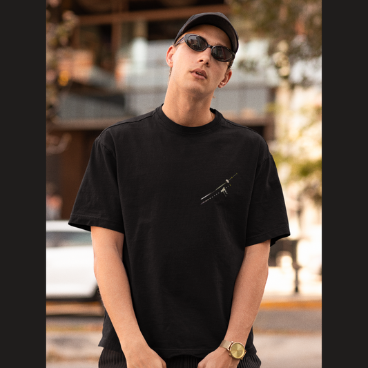 Front view of a male model wearing a black oversized t-shirt featuring Trafalgar Law from the One Piece anime.