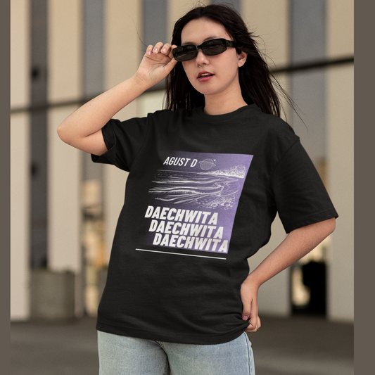 Front view of a female model wearing a black oversized t-shirt featuring a bold design inspired by BTS member Suga's alter ego, August D. Ideal for BTS fans (ARMY) and K-Pop enthusiasts who love rap music and artist individuality.
