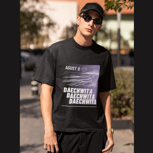 Front view of a male model wearing a black oversized t-shirt featuring a bold design inspired by BTS member Suga's alter ego, August D. Ideal for BTS fans (ARMY) and K-Pop enthusiasts who love rap music and artist individuality.