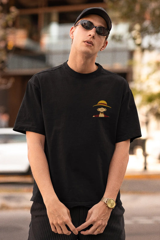 Front view of a male model wearing a black oversized t-shirt featuring Monkey D. Luffy from the One Piece anime.